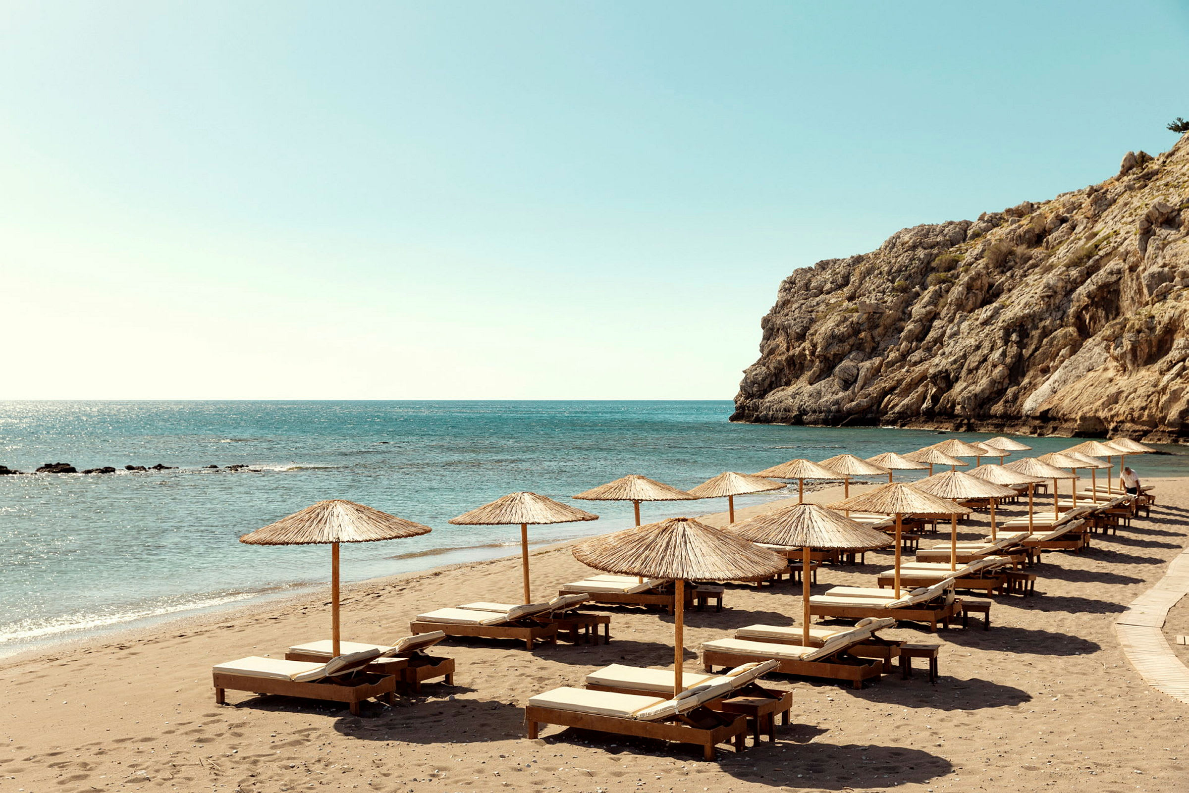 Strand med solstolar och parasoller vid havet. (AI-genererad text)