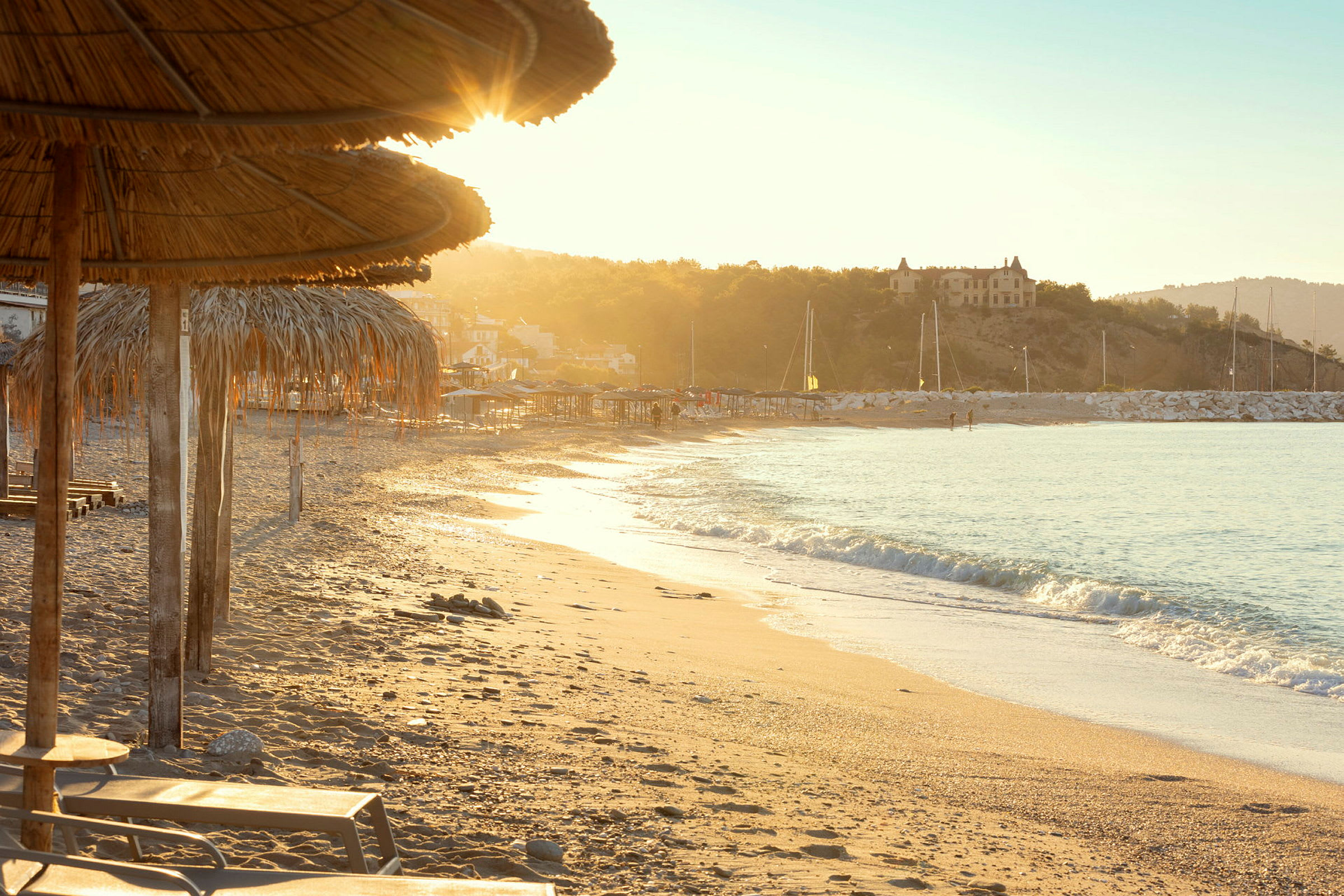 Strand med solnedgång och parasoller. (AI-genererad text)