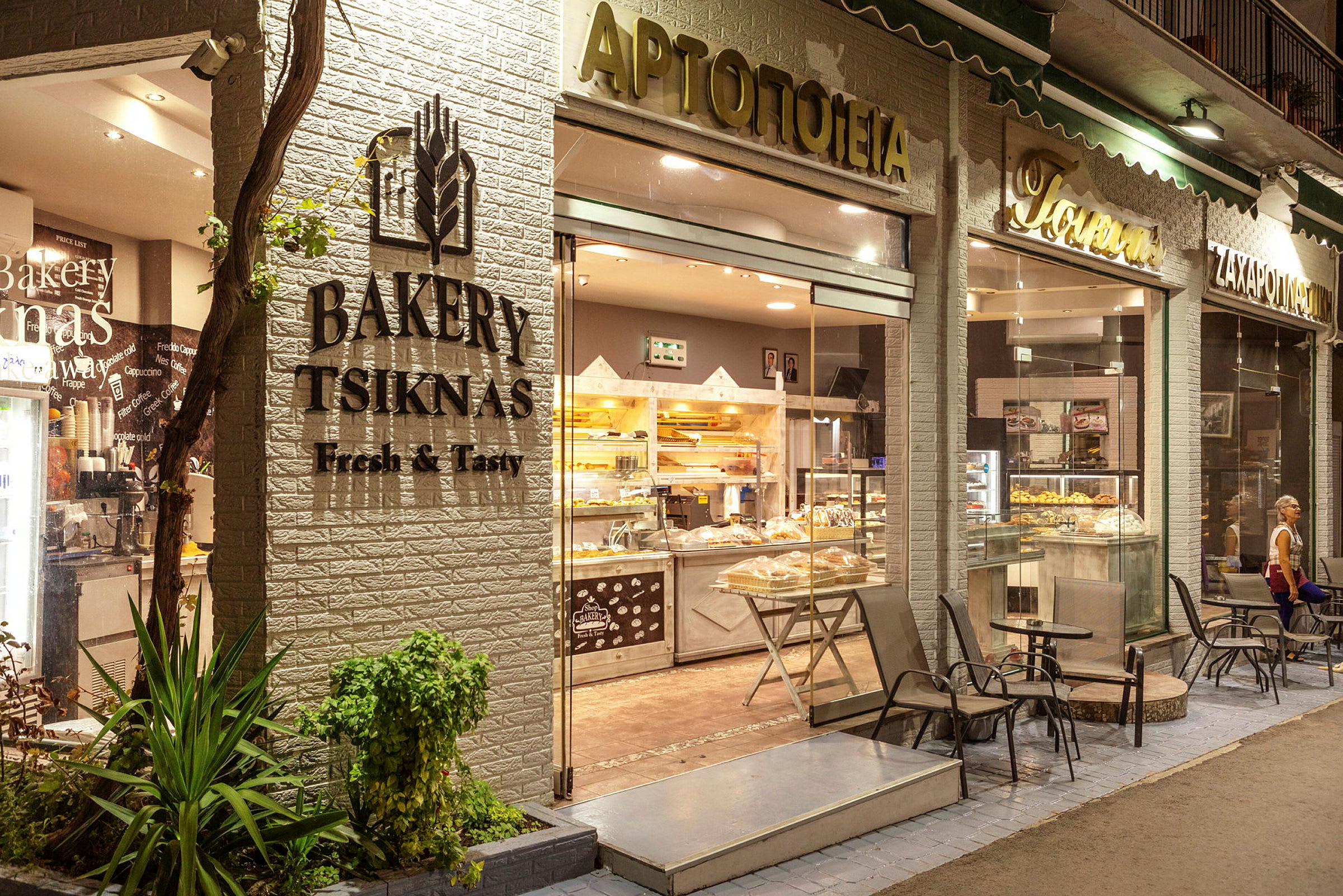 Bakery Tsiknas vid nattadörren med kafébord utanför. (AI-genererad text)