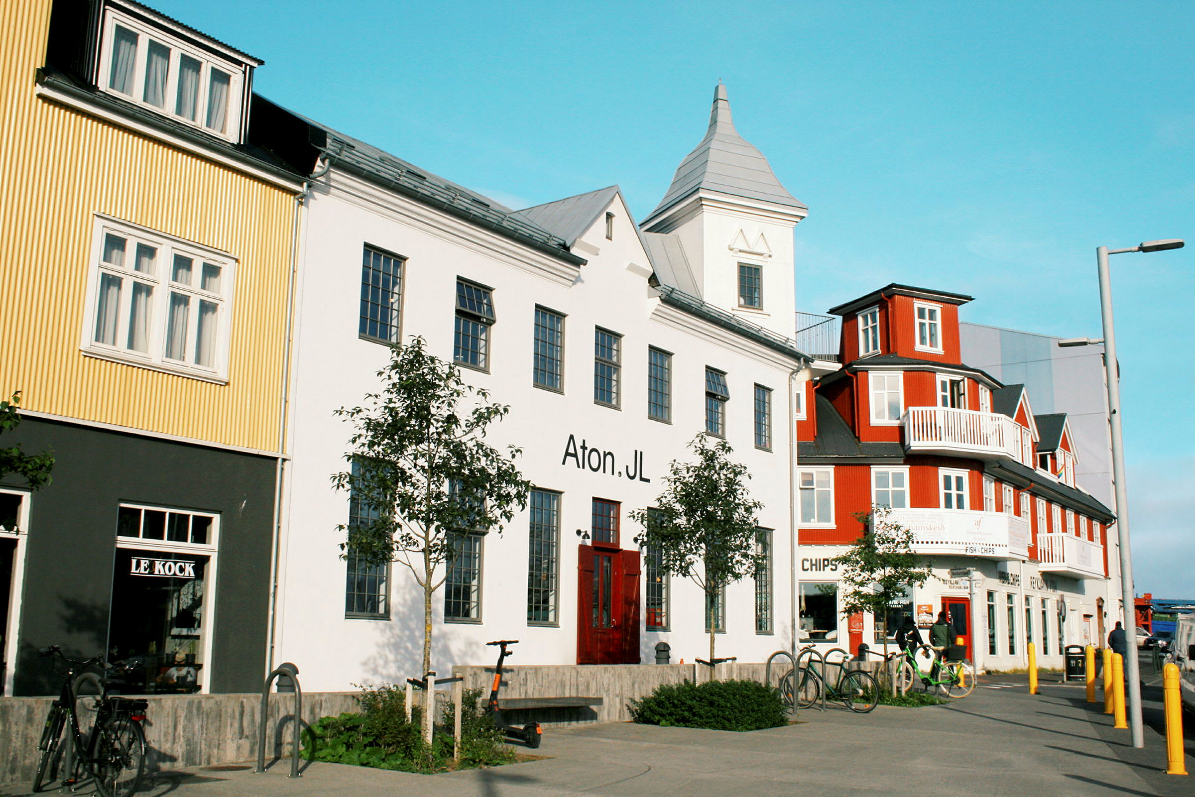 Flera färgglada byggnader längs en gata med cyklar parkerade framför. (AI-genererad text)
