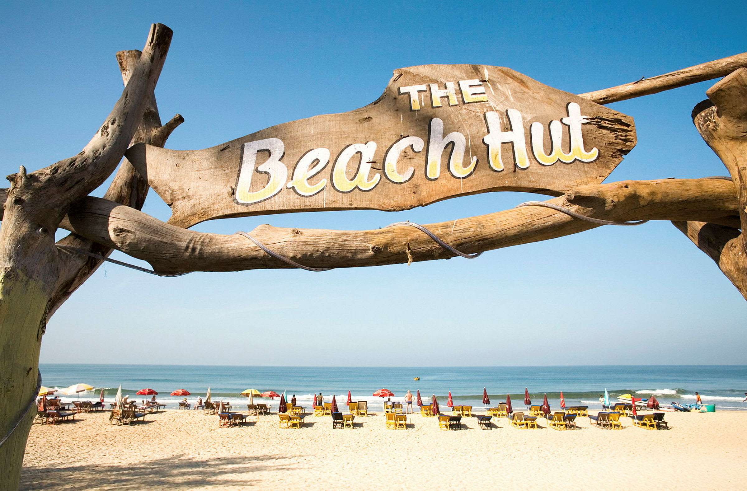 En bild av en strand med en skylt där det står "The Beach Hut" i förgrunden. (AI-genererad text)