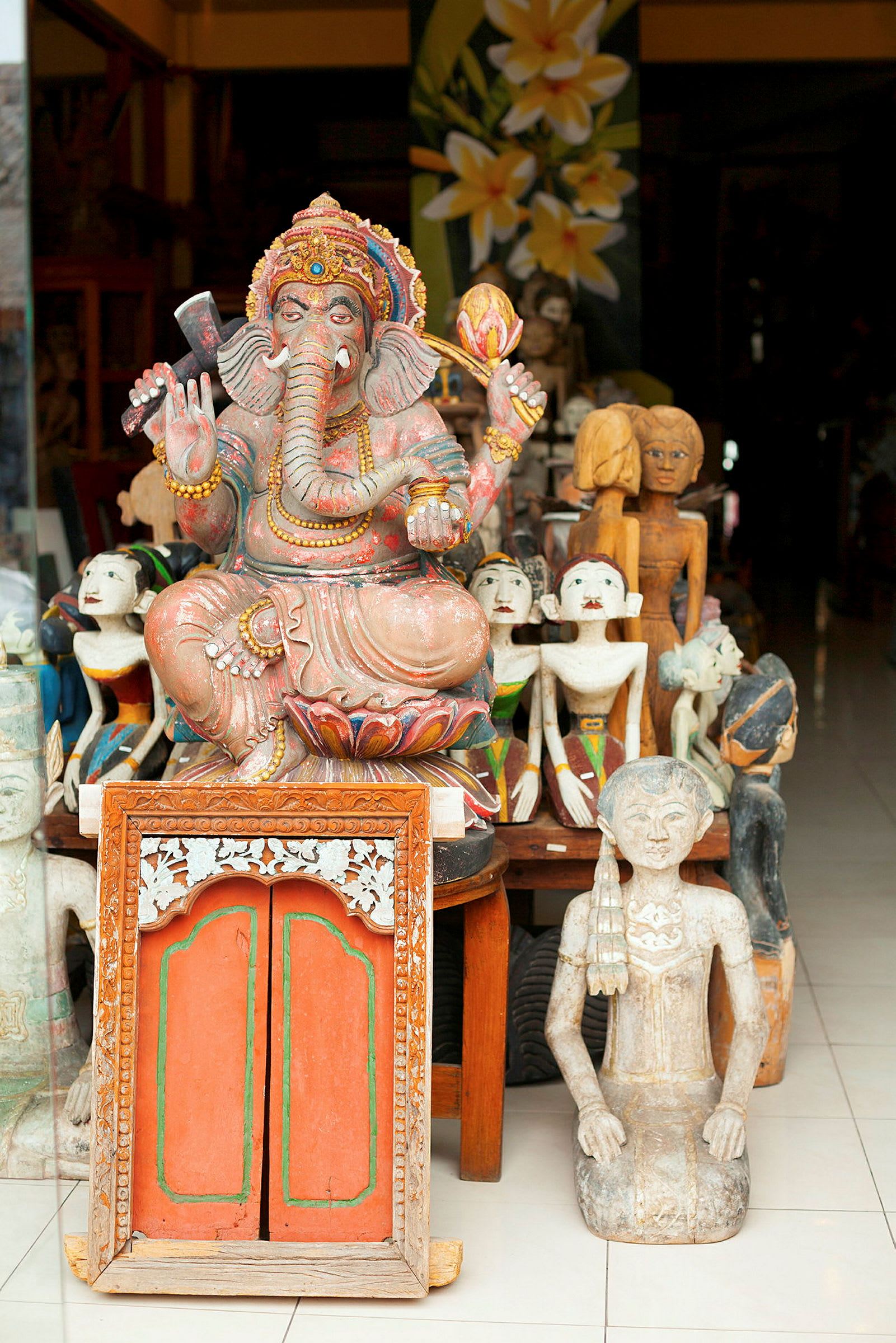 Dekorerad staty av Ganesha och andra skulpturer placerade på en butikshylla. (AI-genererad text)