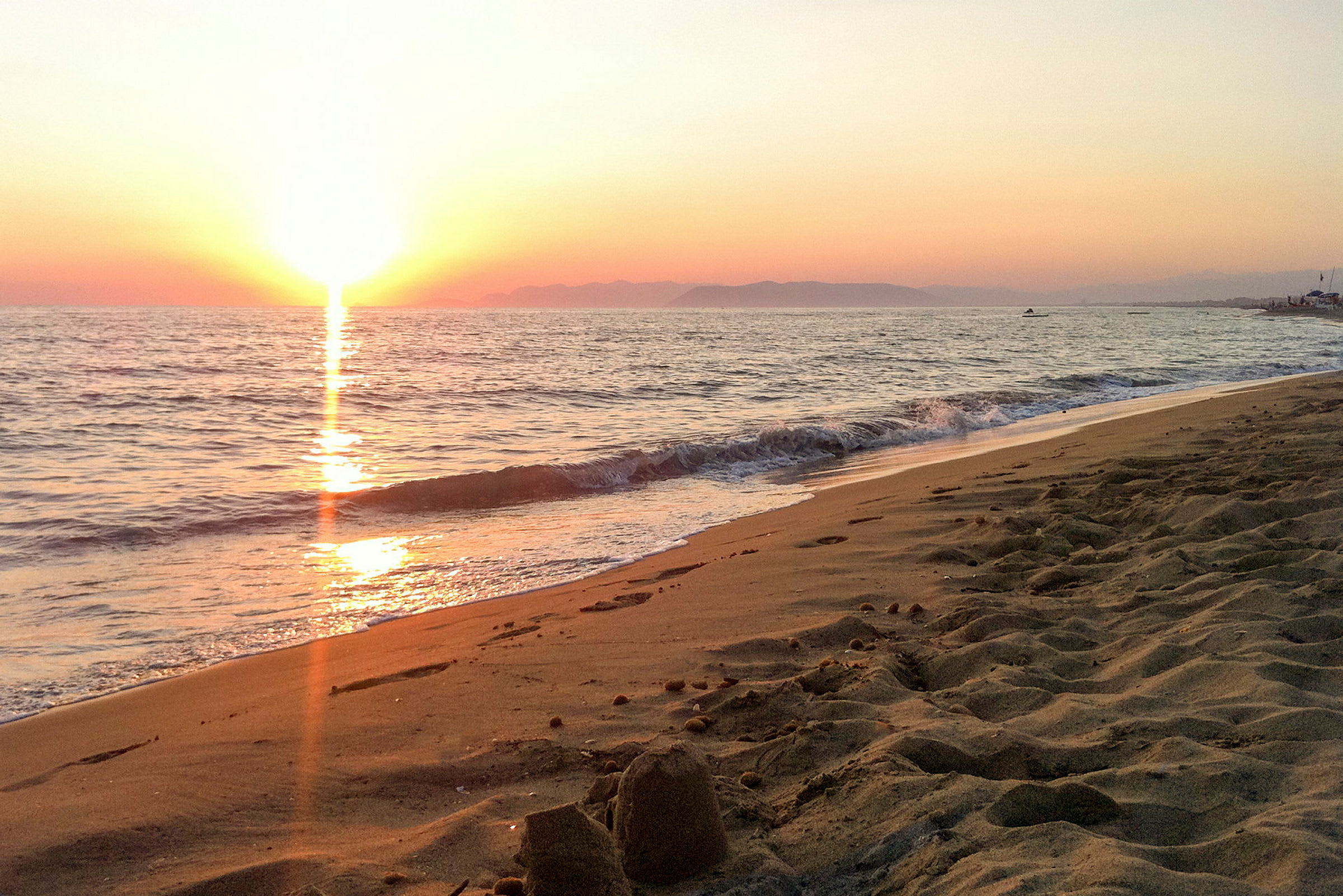 Solnedgång över havet vid en sandstrand. (AI-genererad text)
