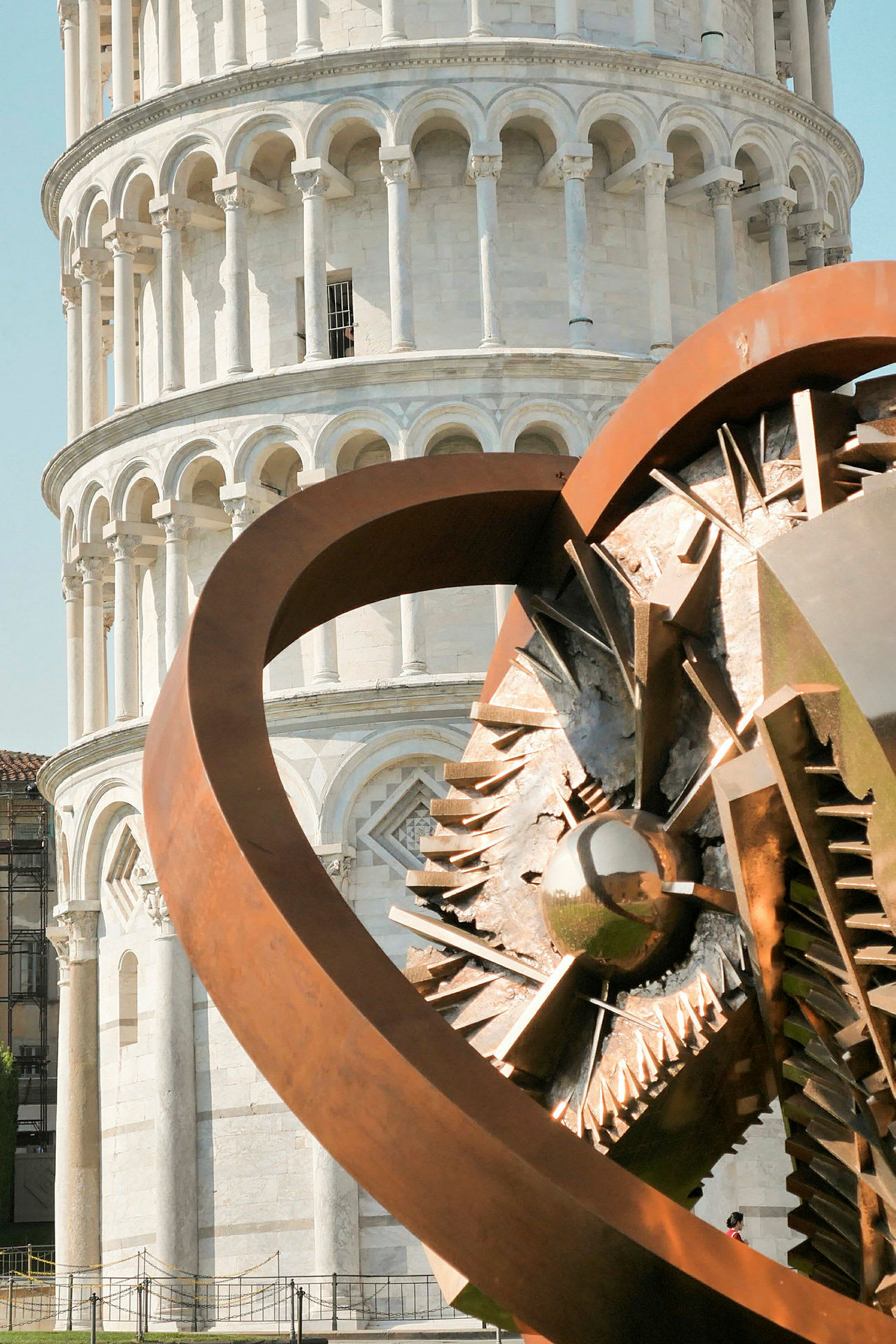 Bild på lutande tornet i Pisa, med en modern metallskulptur i förgrunden. (AI-genererad text)