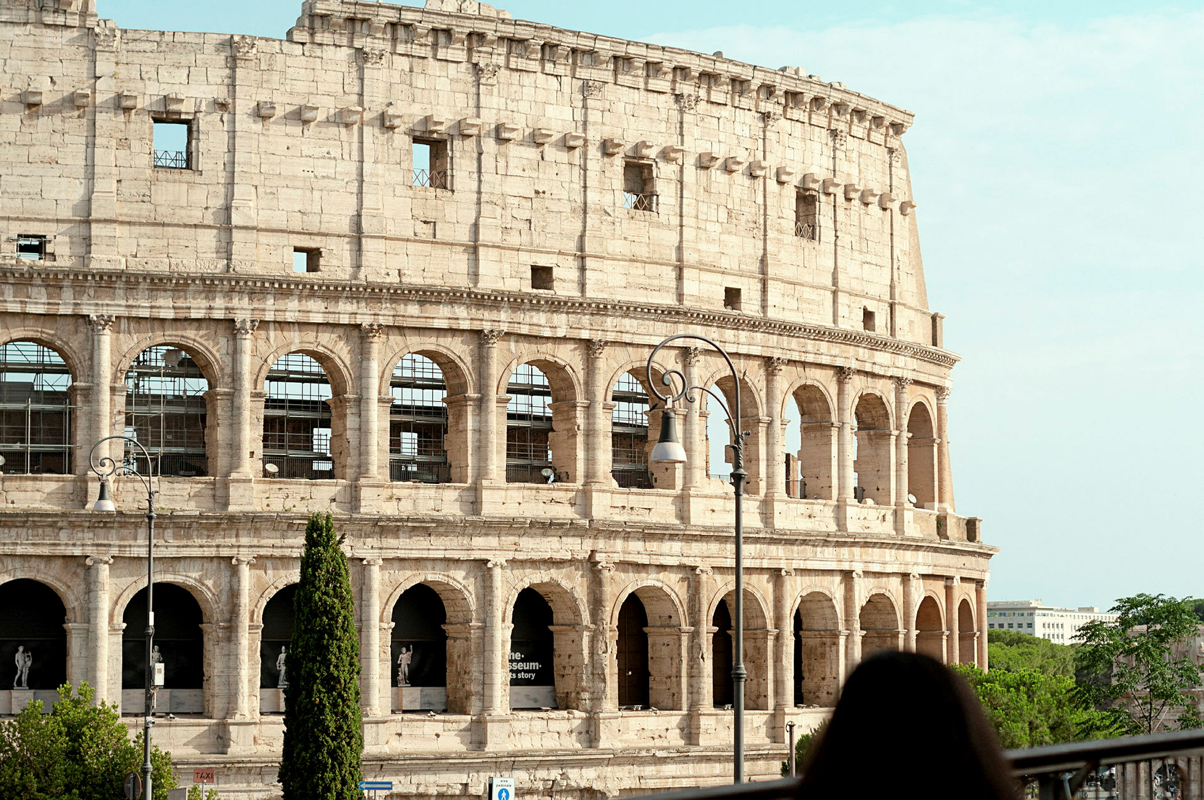 Bild av Colosseum i Rom, Italien, med en kvinna i förgrunden. (AI-genererad text)