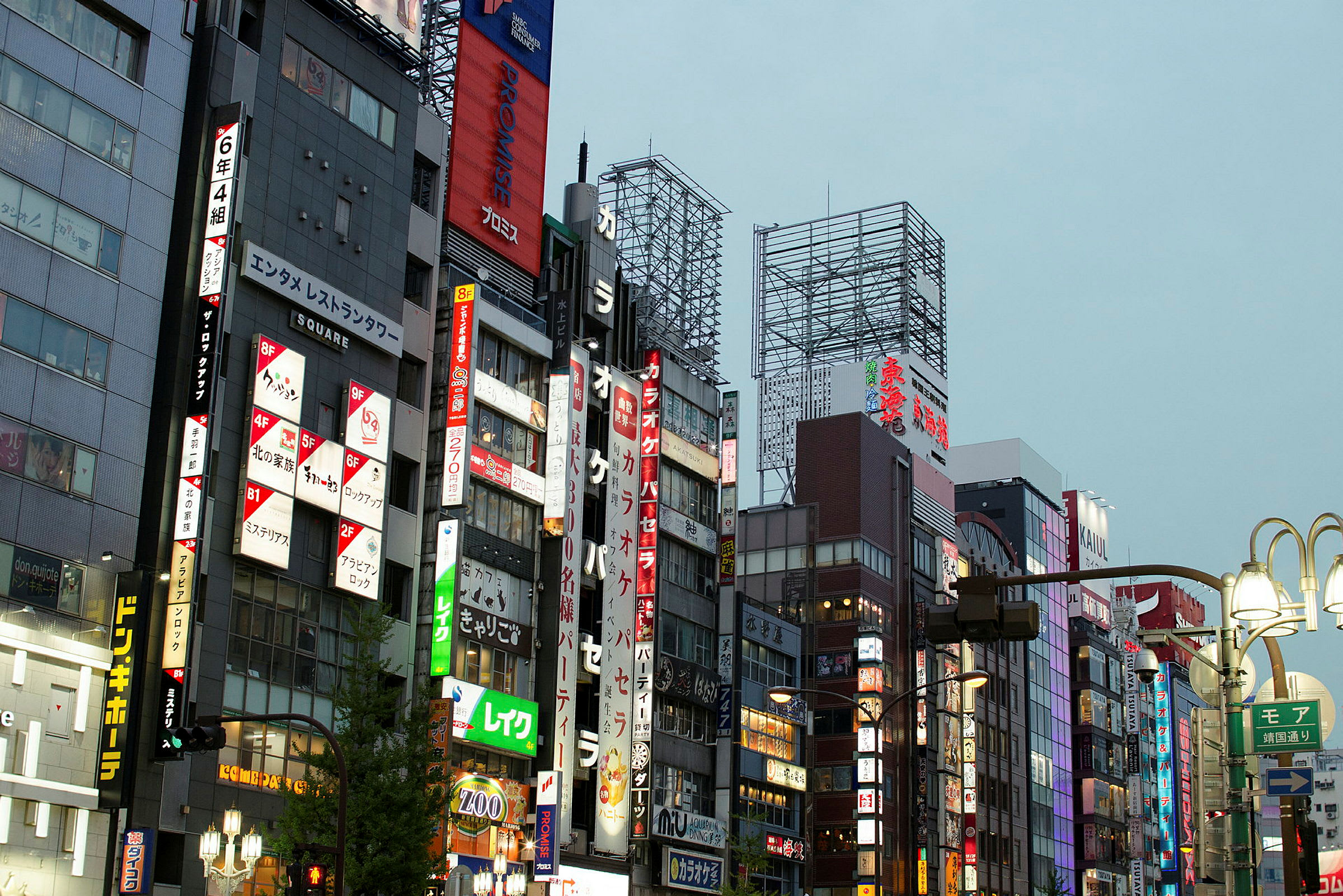 Flerbostadshus längs en gata med lysande japanska skyltar och reklam. (AI-genererad text)