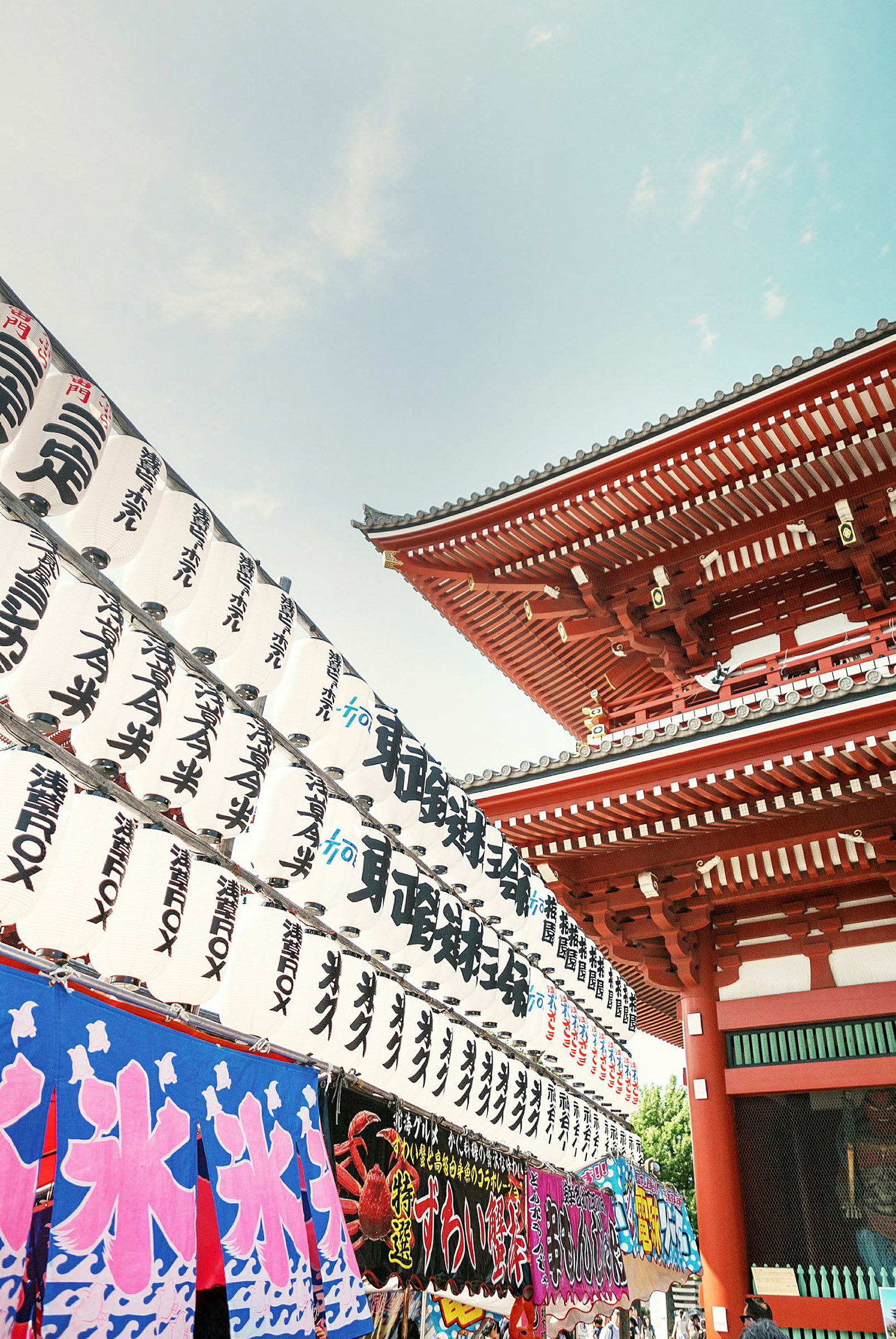 Japanskt tempel med röda byggnader och dekorationer samt traditionella vita lyktor med japanska tecken. (AI-genererad text)
