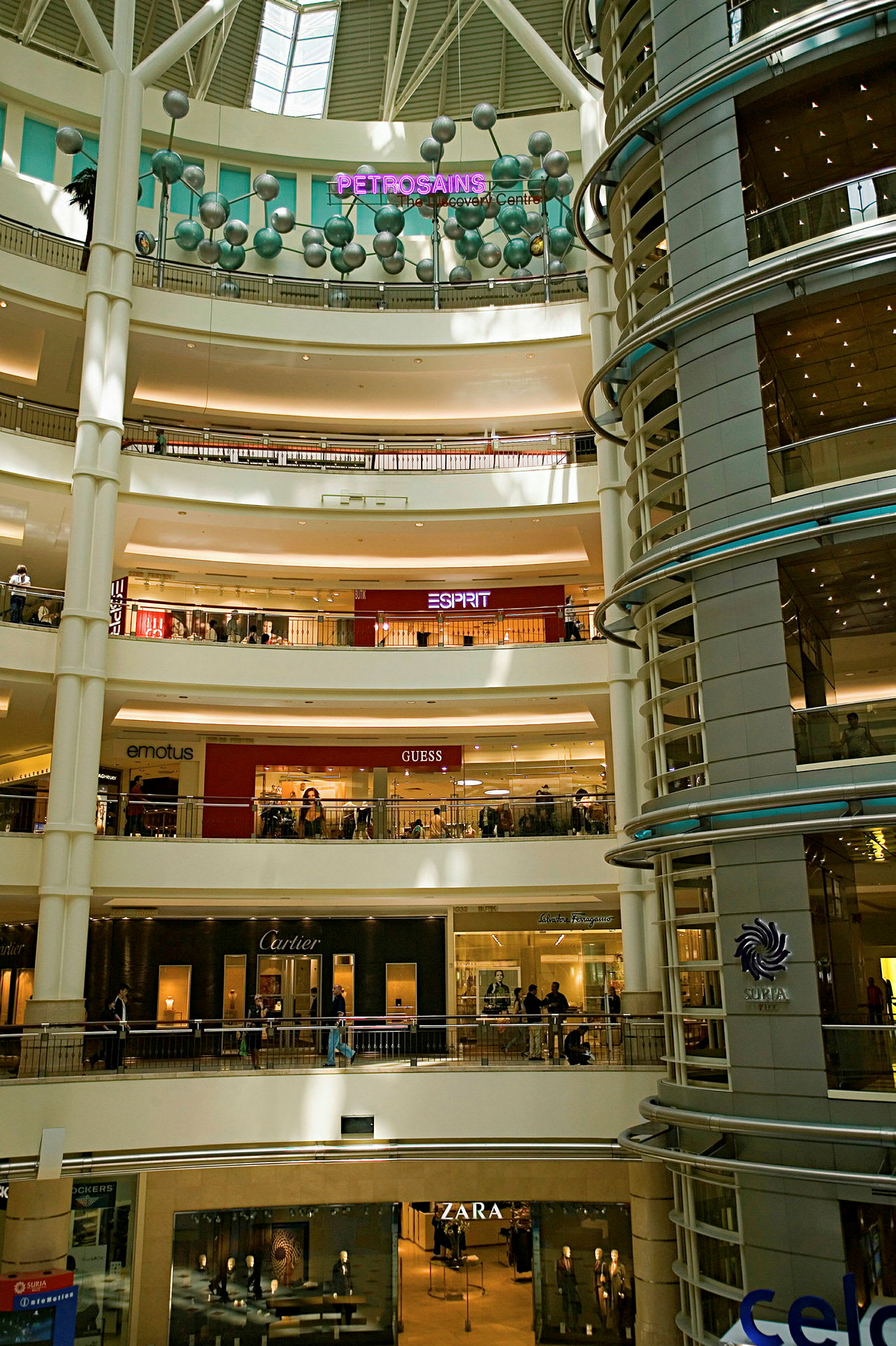 En fler våningars inomhusgalleria med butiker och skyltar. (AI-genererad text)
