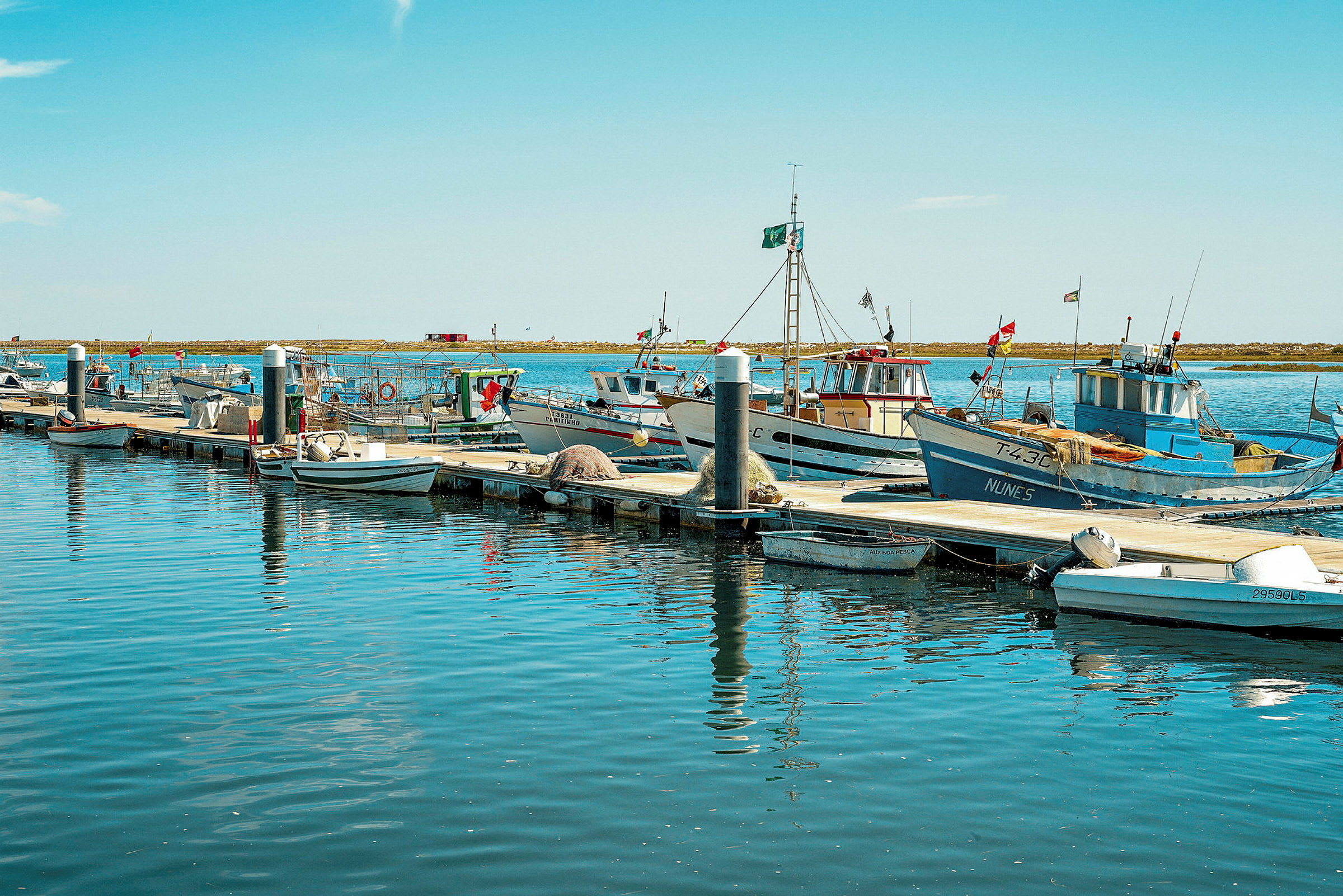 Fiskebåtar förtöjda vid bryggan i en hamn. (AI-genererad text)