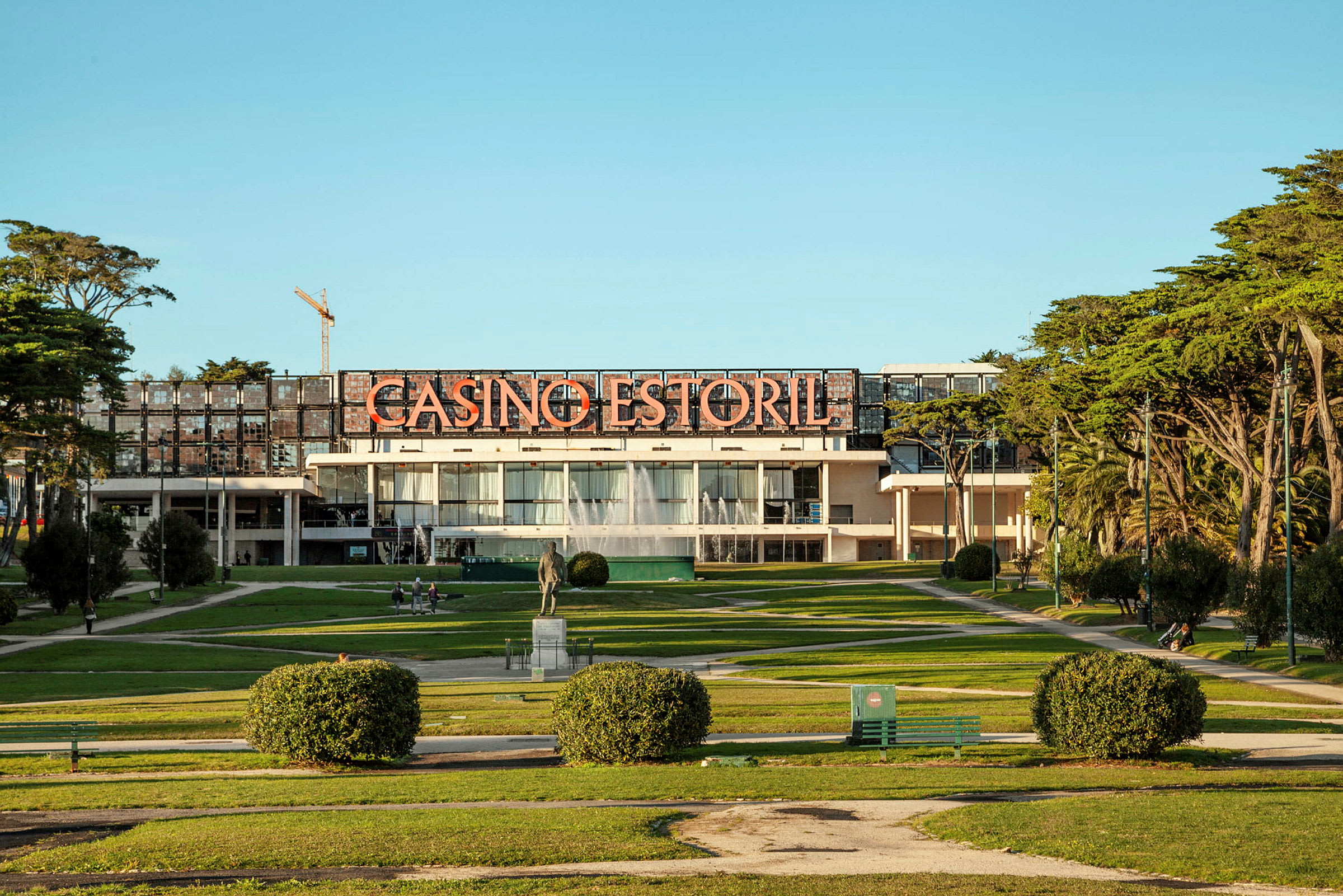 Bild av Casino Estoril, omgiven av grönska och gångvägar. (AI-genererad text)