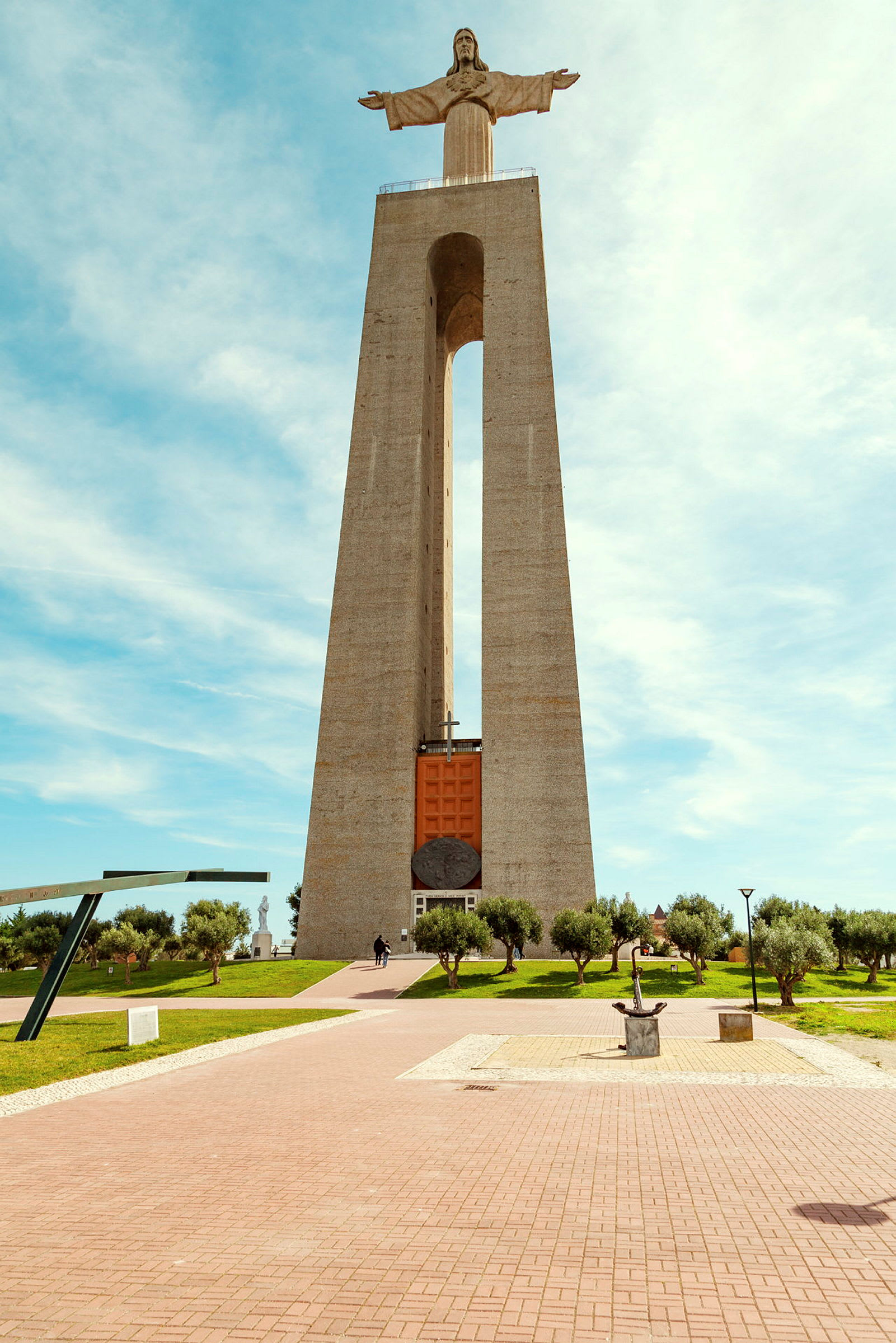 Monument med en Kristusstaty på toppen, omgiven av en park. (AI-genererad text)