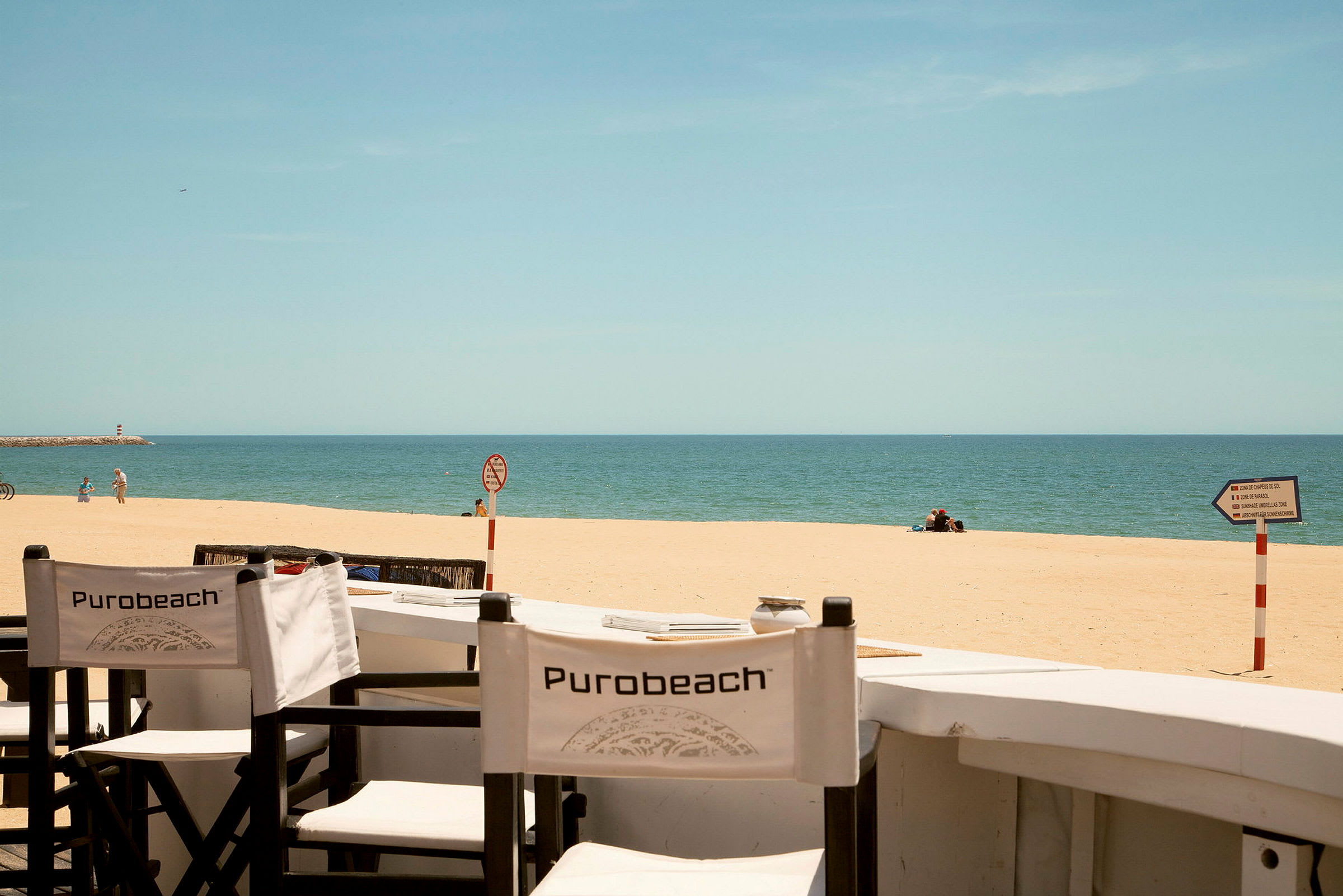 Strandstolar på en sandstrand med havet i bakgrunden. (AI-genererad text)