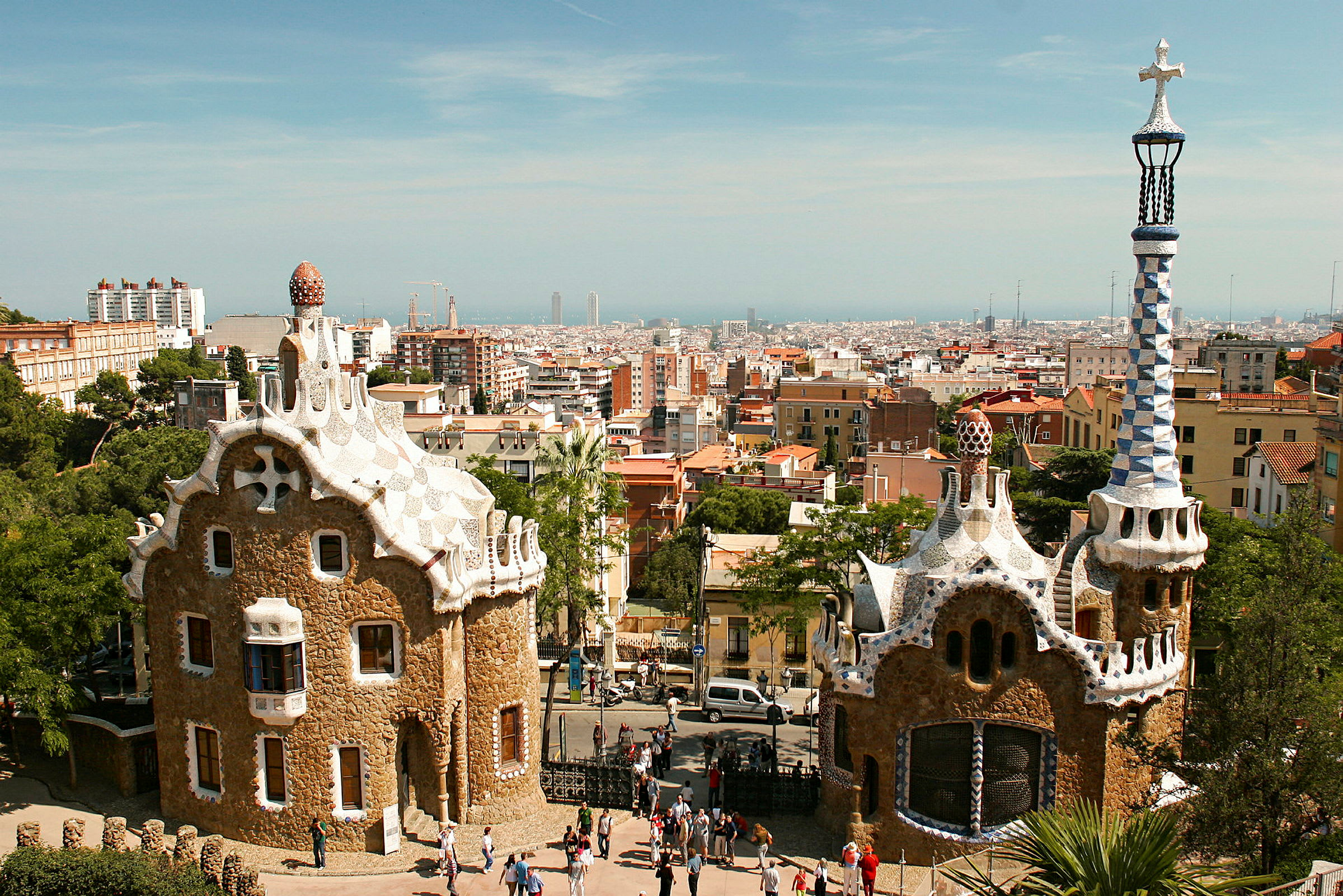 Bild av två unika byggnader i Park Güell, Barcelona, med staden i bakgrunden. (AI-genererad text)