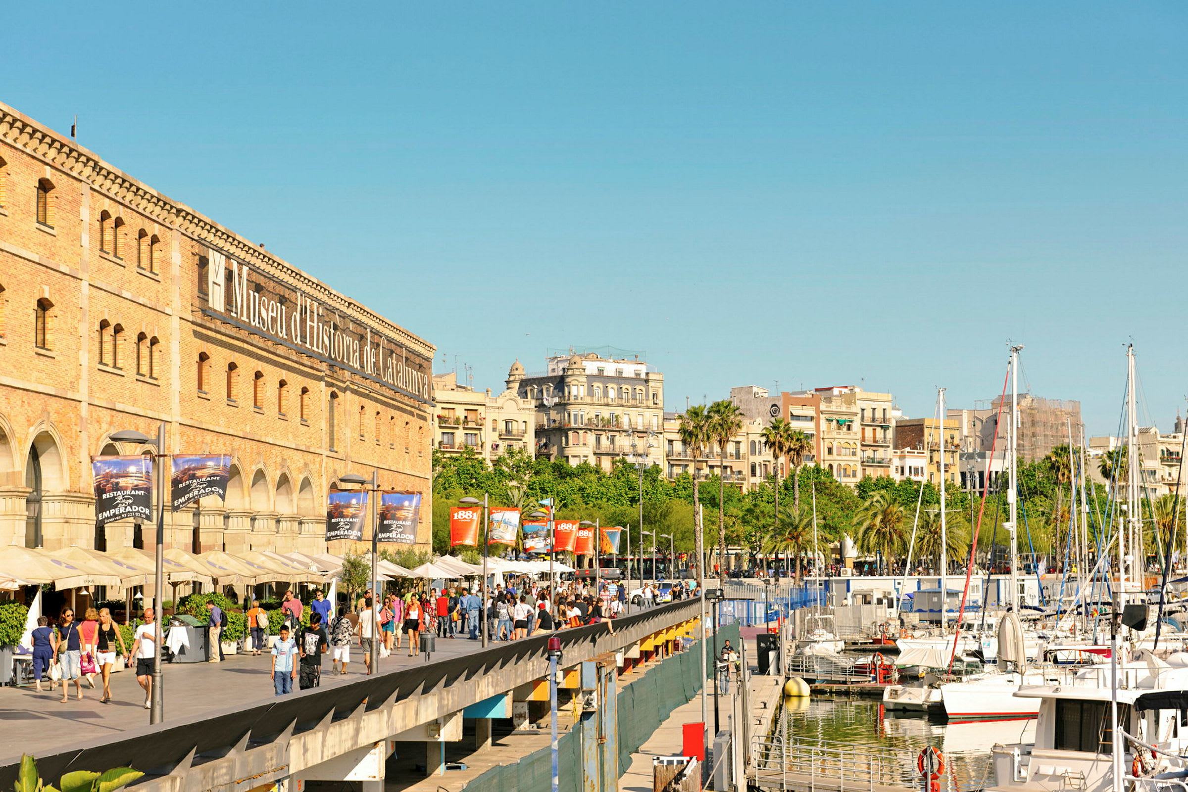 Promenad nära Museu d'Història de Catalunya och båtar i en hamn. (AI-genererad text)