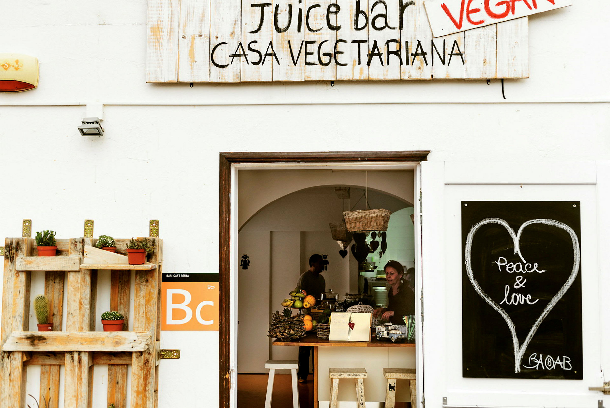 Entré till en juicebar med skyltar och dekorationer. (AI-genererad text)