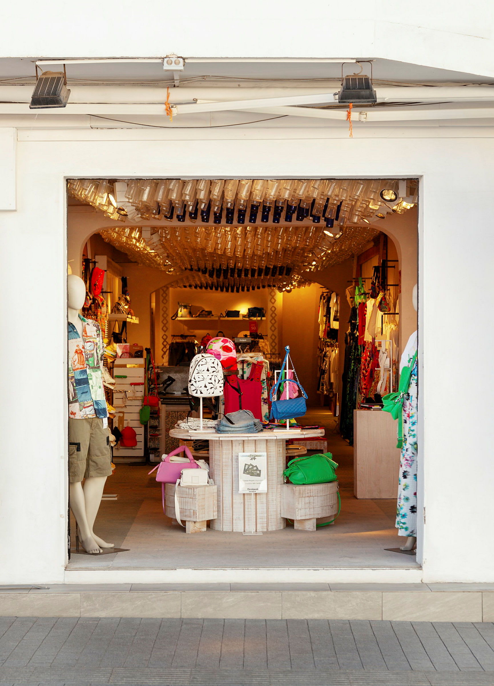 En butik med kläder och accessoarer sedd från dess öppna entré. (AI-genererad text)
