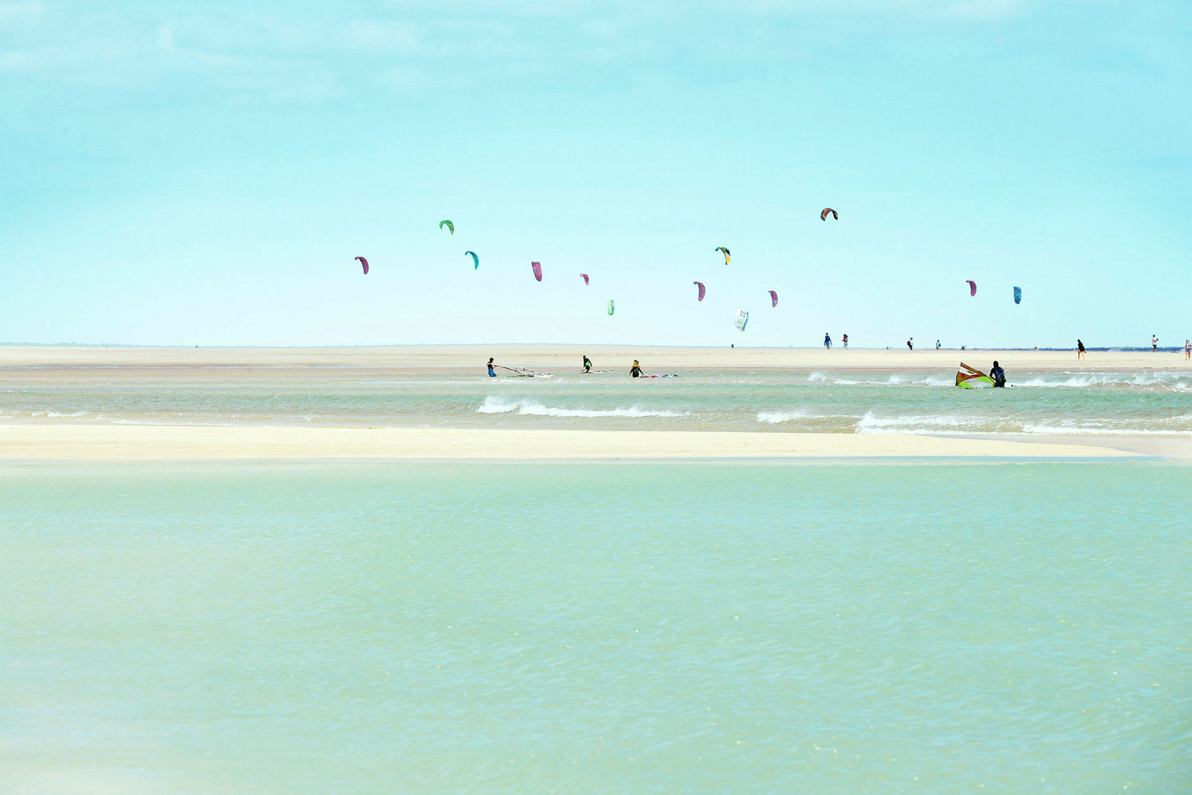 Strand med människor som utövar kitesurfing. (AI-genererad text)