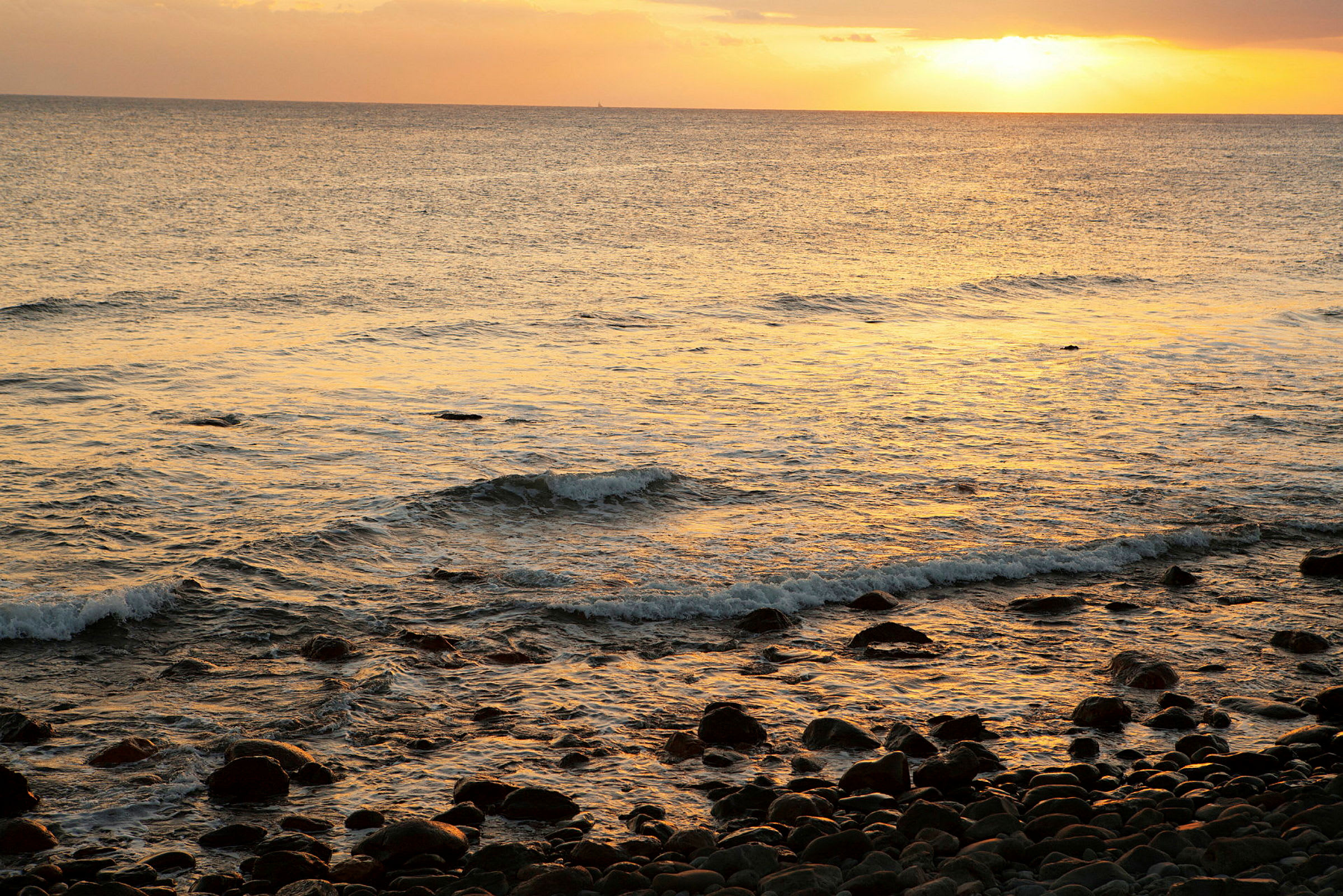 En strand med stenar vid solnedgång. (AI-genererad text)