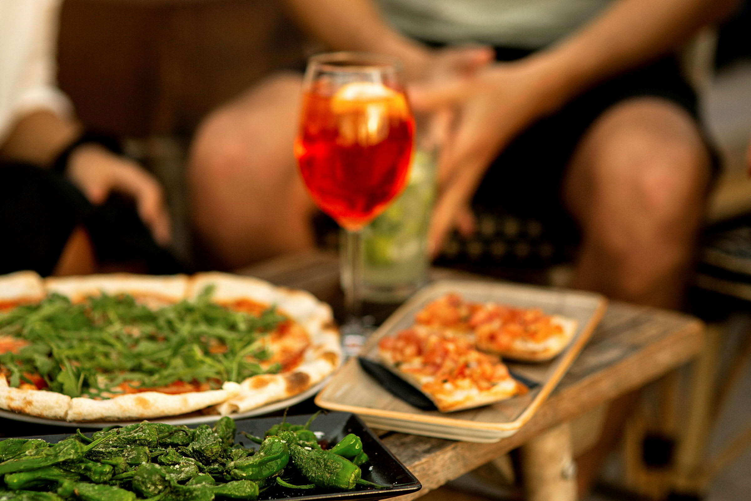 En display med pizza, grillad paprika och bruschetta serverad tillsammans med en drink. (AI-genererad text)