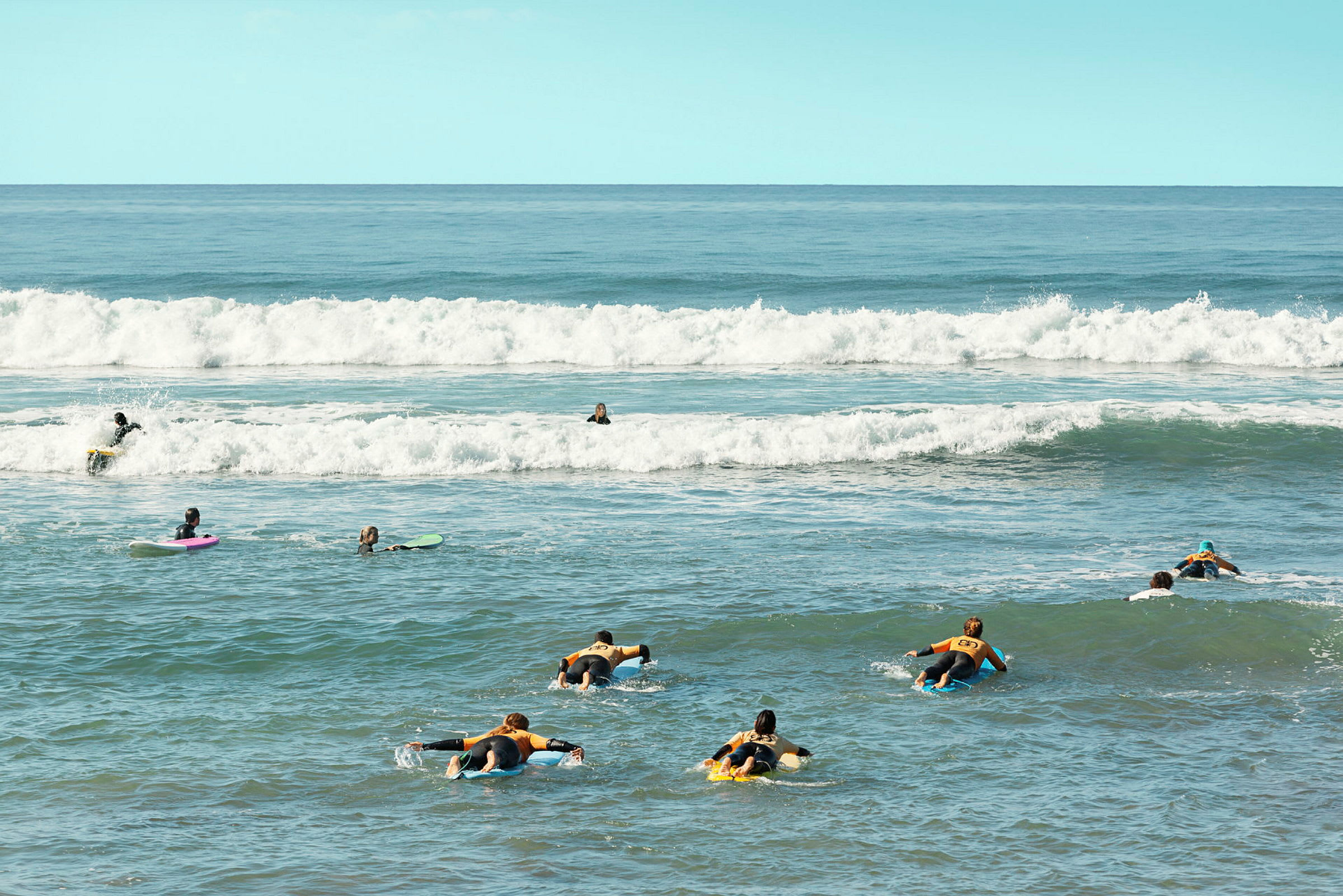 Personer som paddlar på surfbrädor i havet. (AI-genererad text)