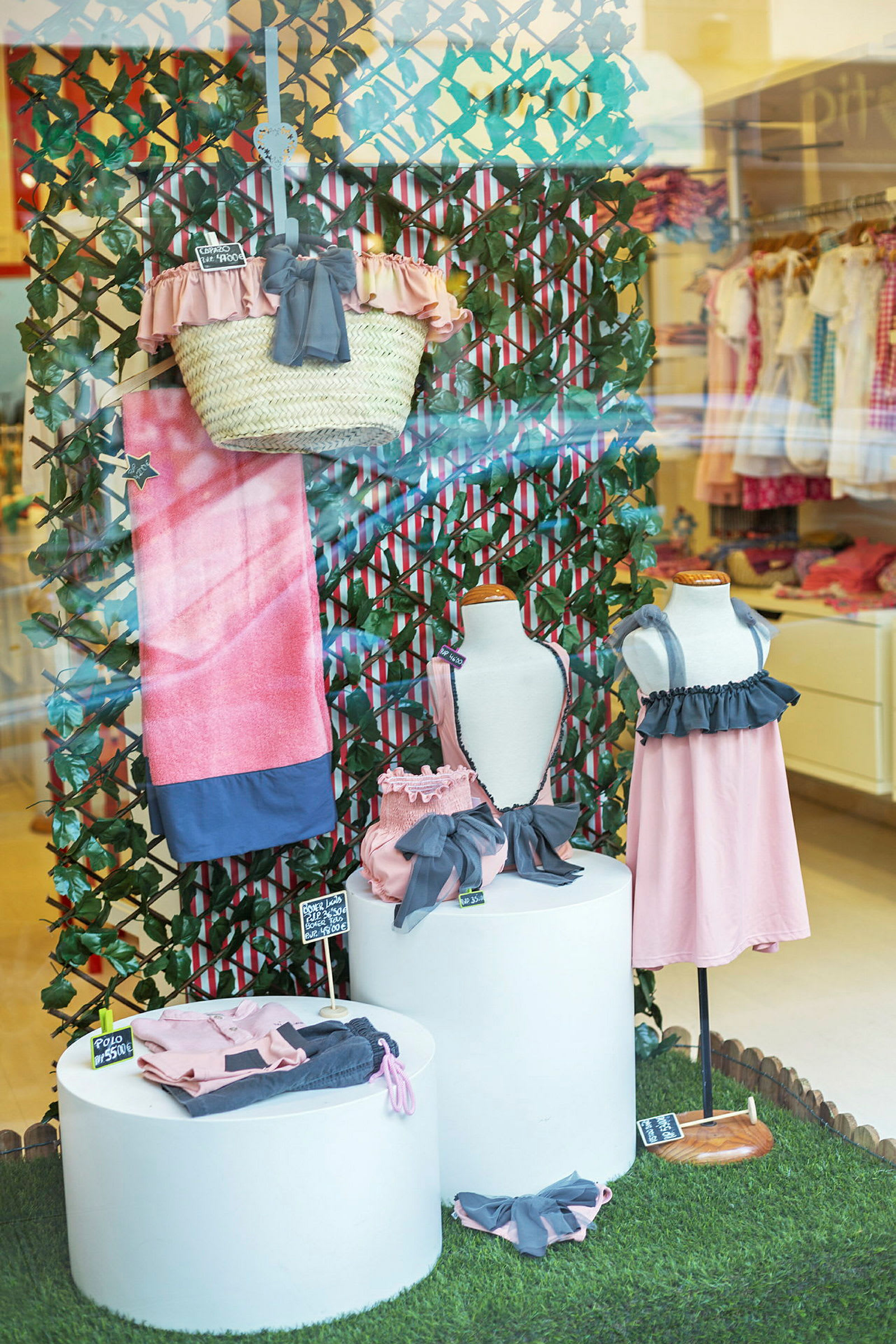 Utställning med barnkläder och accessoarer i rosa och blått. (AI-genererad text)