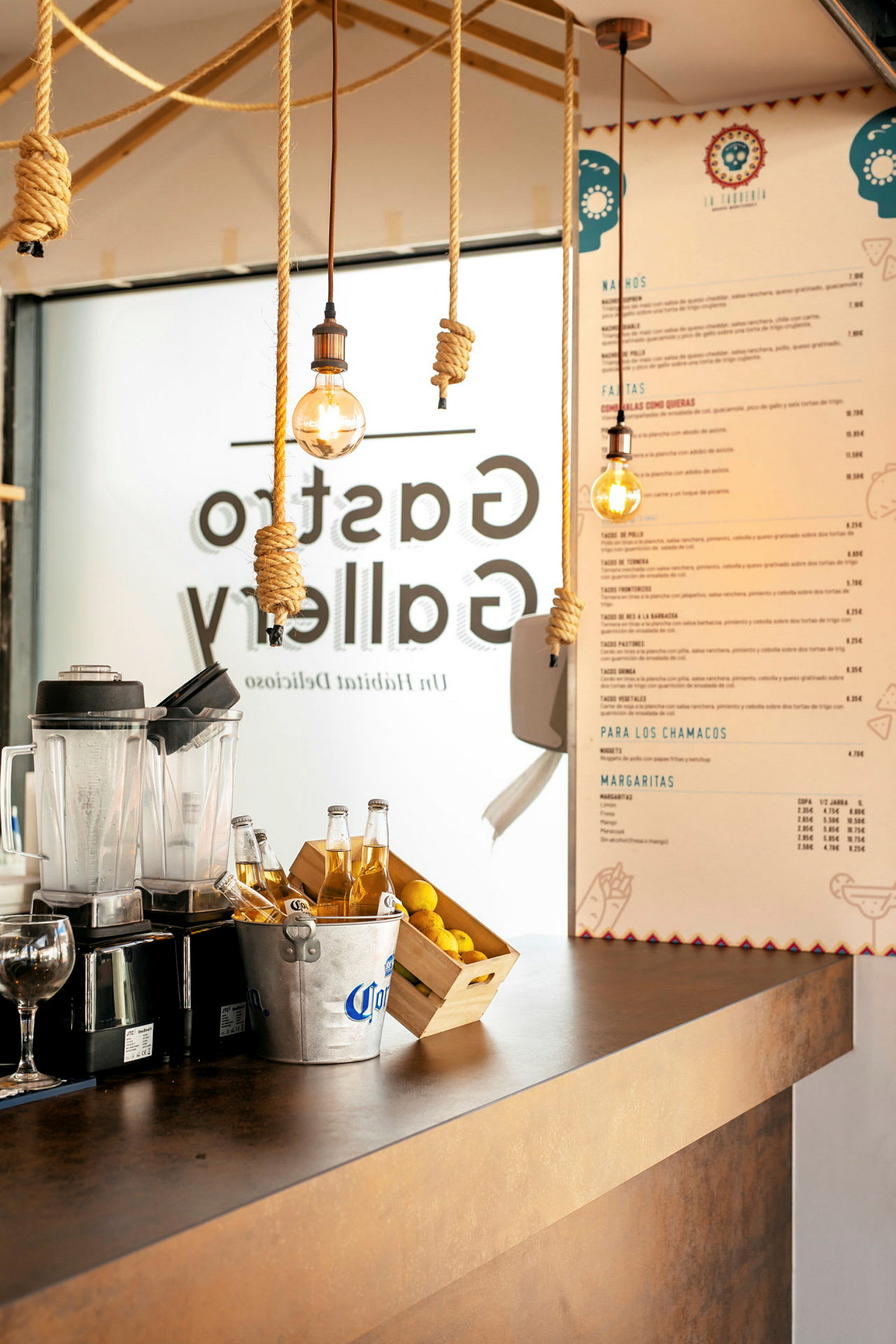 Disk i en restaurang med mixer, ölkärl, citroner och meny på väggen. (AI-genererad text)
