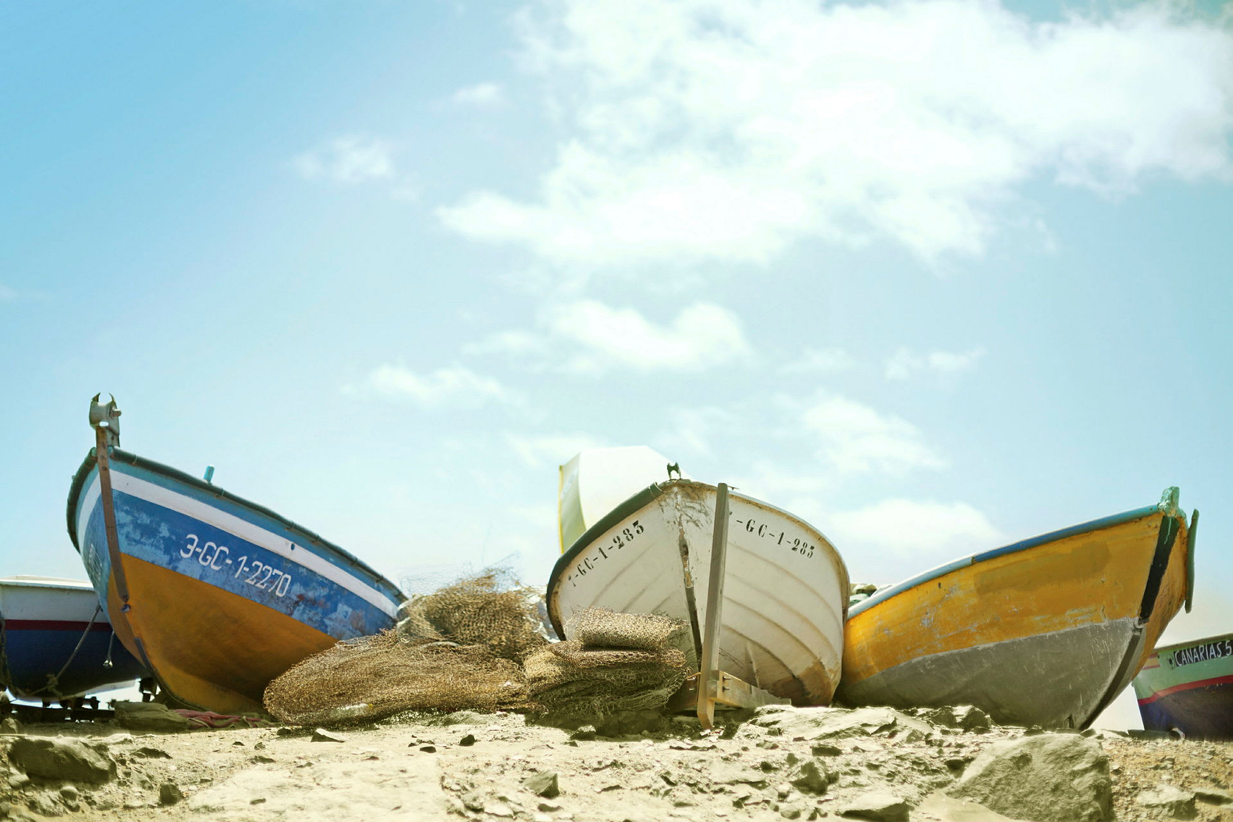 Flera små båtar står uppställda på en strand. (AI-genererad text)