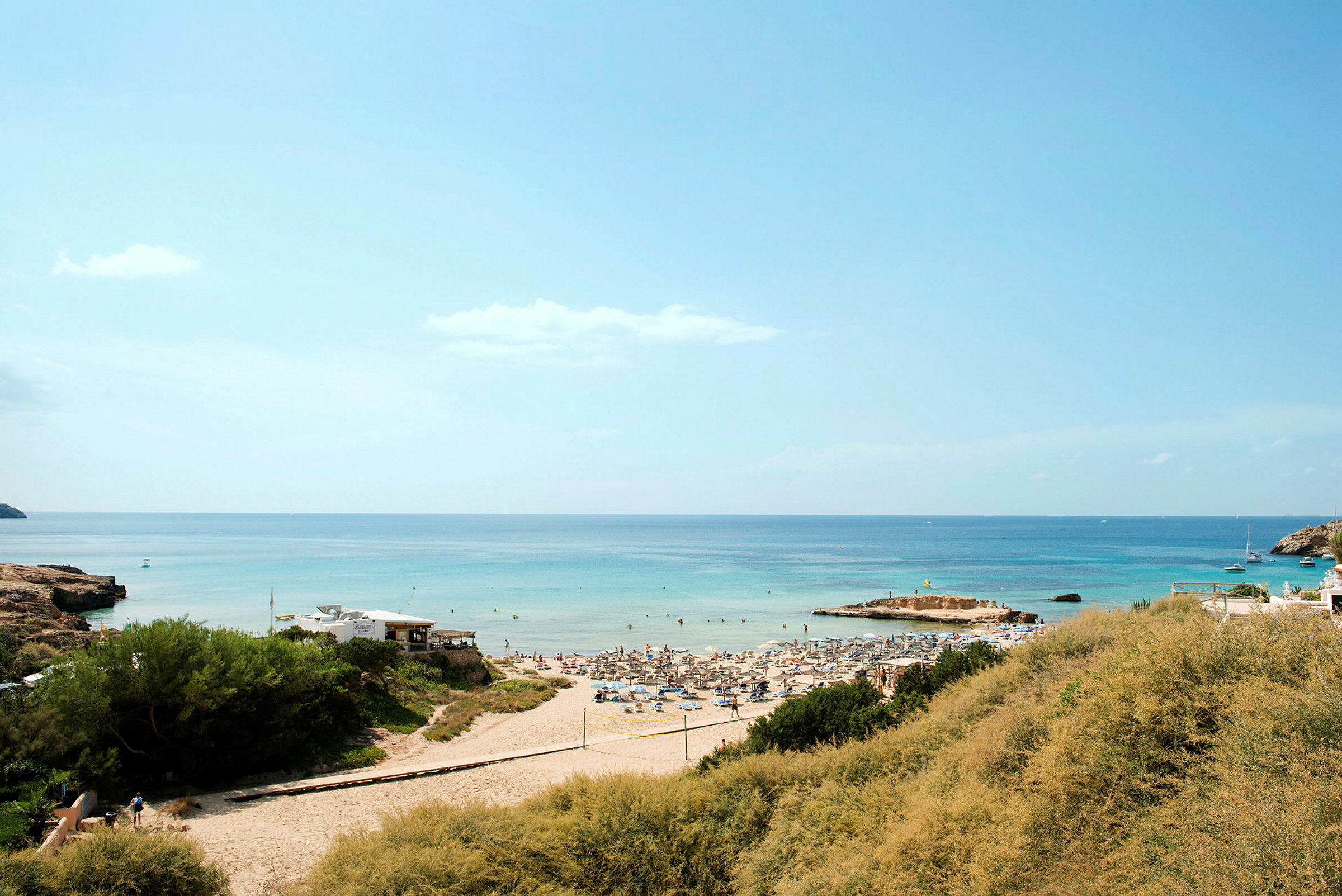 Sandstrand med solstolar och parasoller, vid havet. (AI-genererad text)