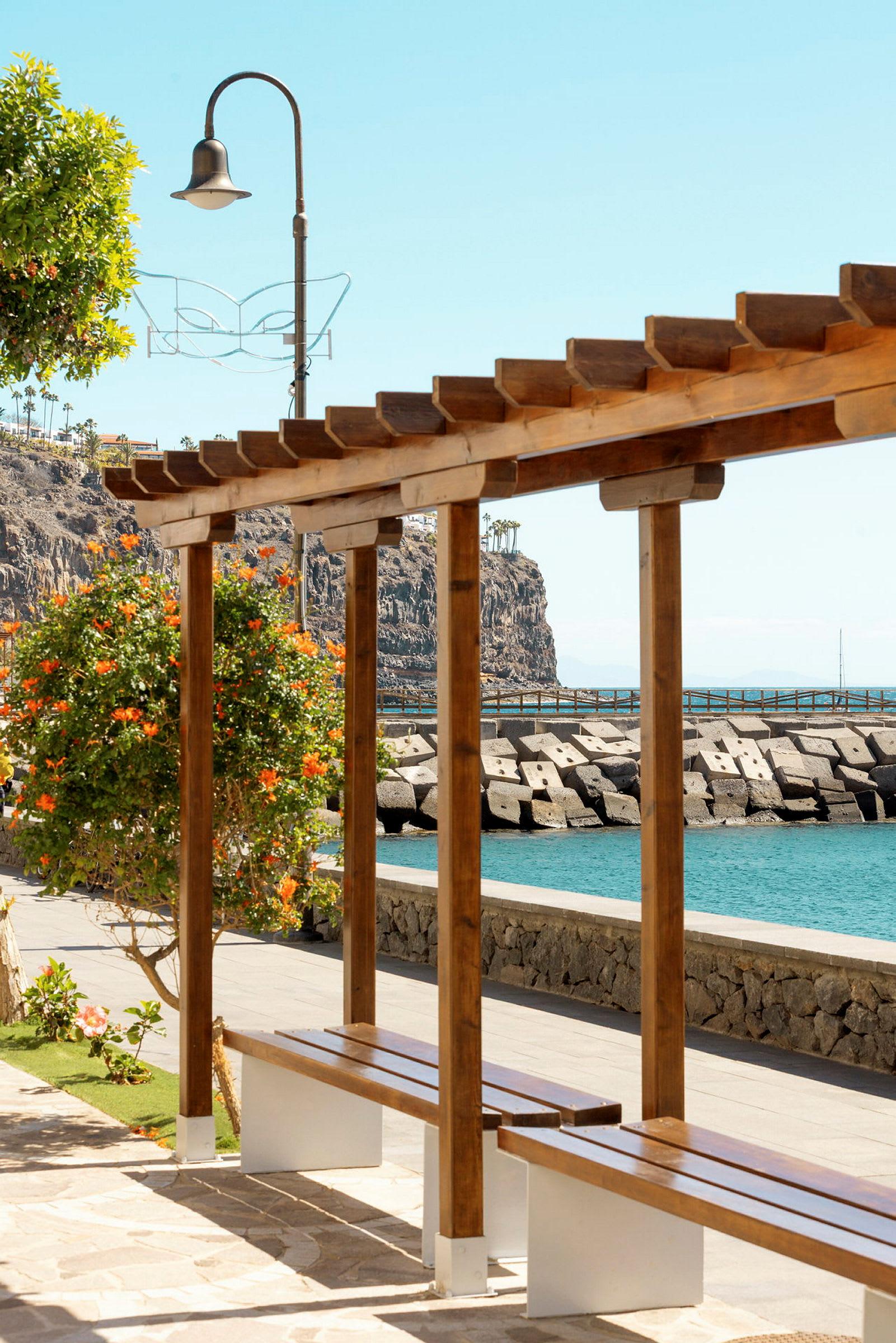 Träpergola med bänk vid havet. (AI-genererad text)