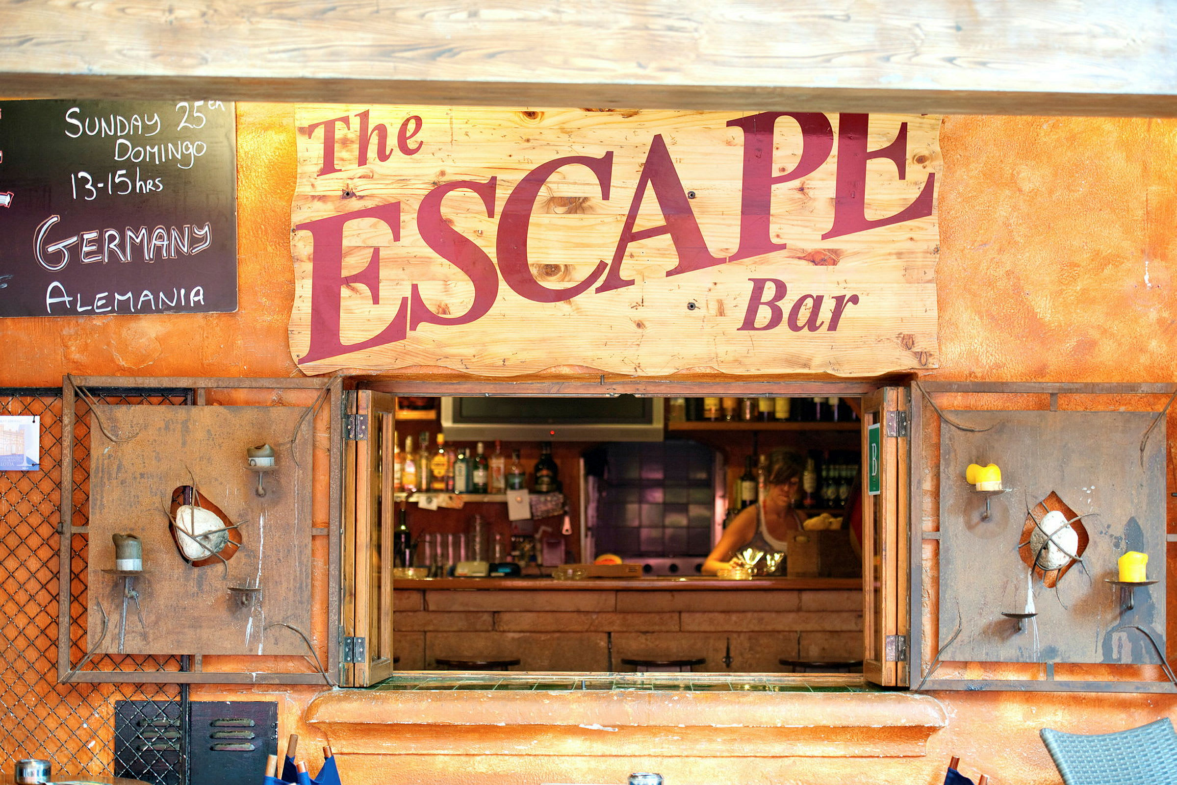En bar med namnet 'The Escape' visas, inklusive en skylt med text och en öppning till baren. (AI-genererad text)