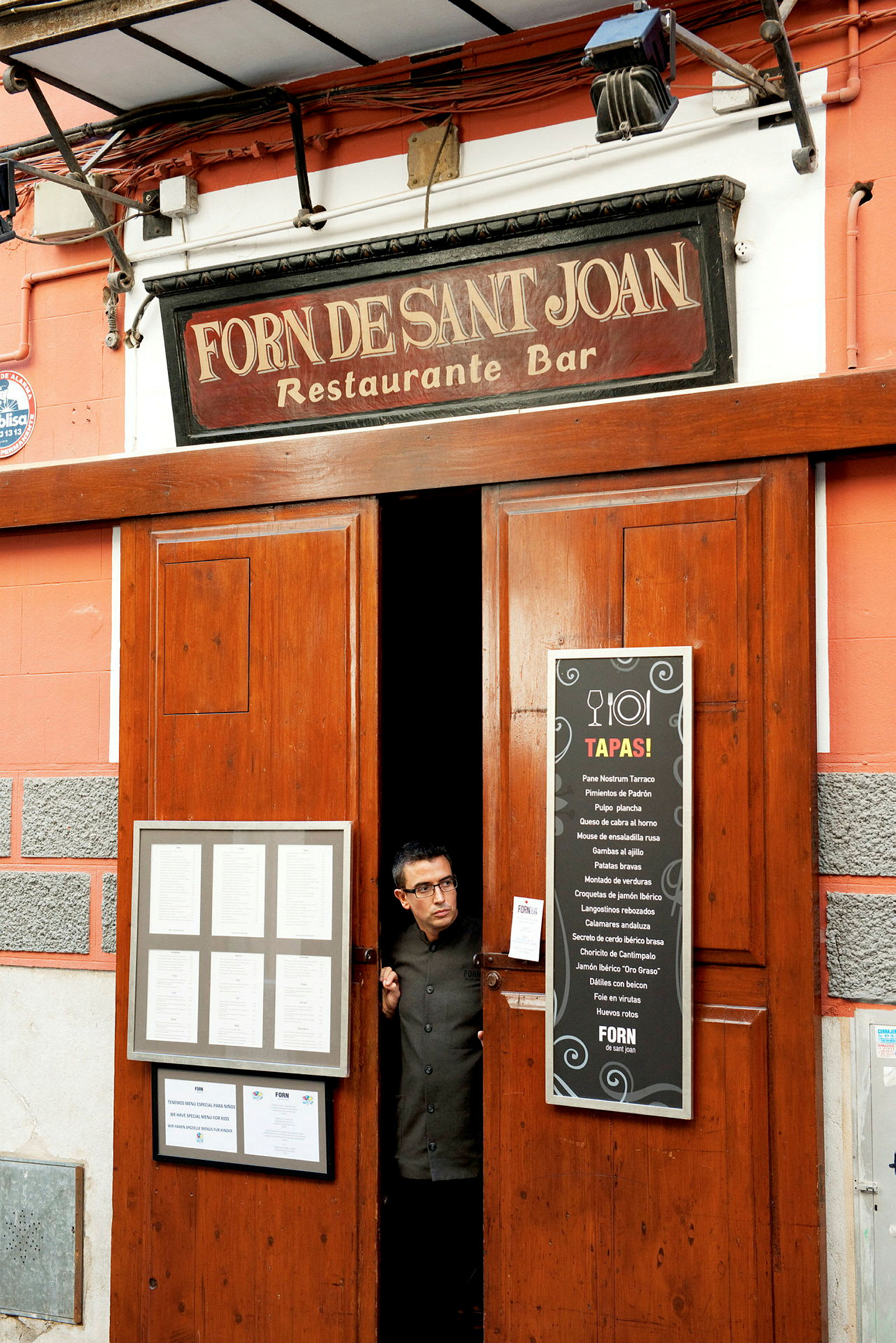 Entré till restaurang och bar med skylt som visar namnet 'Forn Desant Joan' och menyer på utsidan. (AI-genererad text)