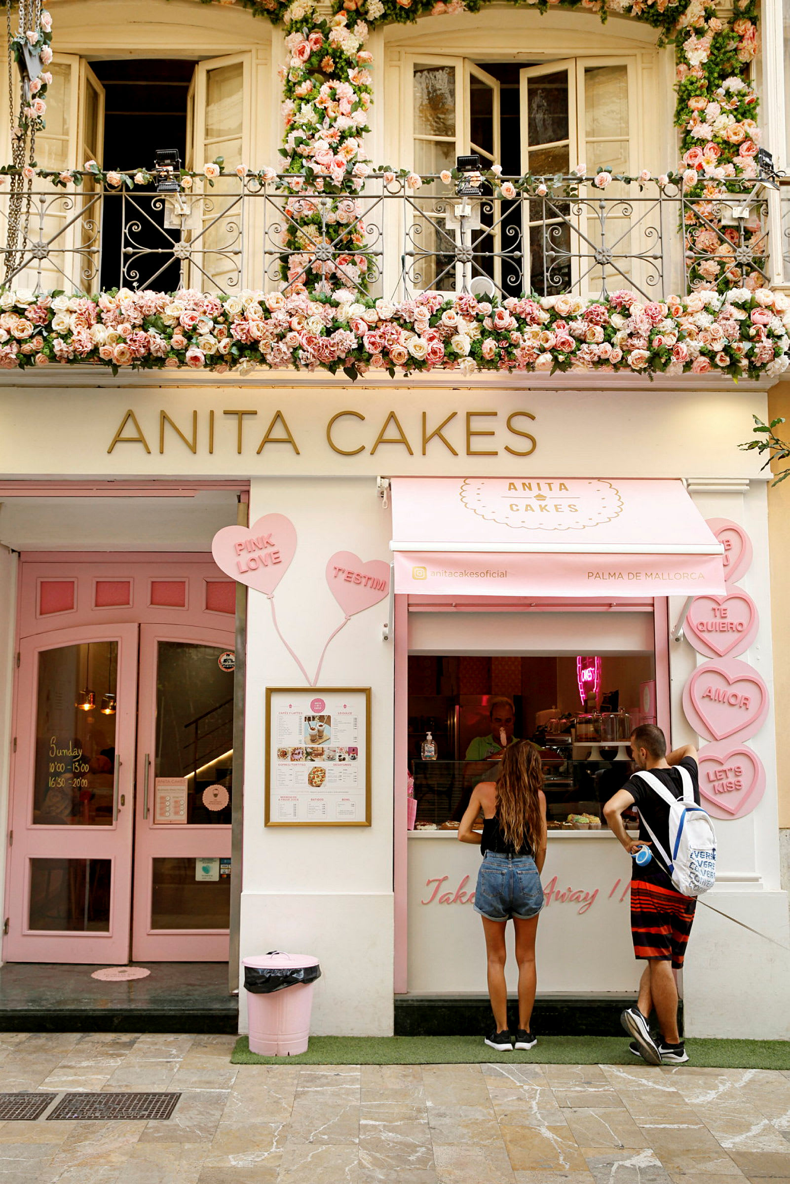 Dekorativt kafé med många blommor och skyltar. (AI-genererad text)