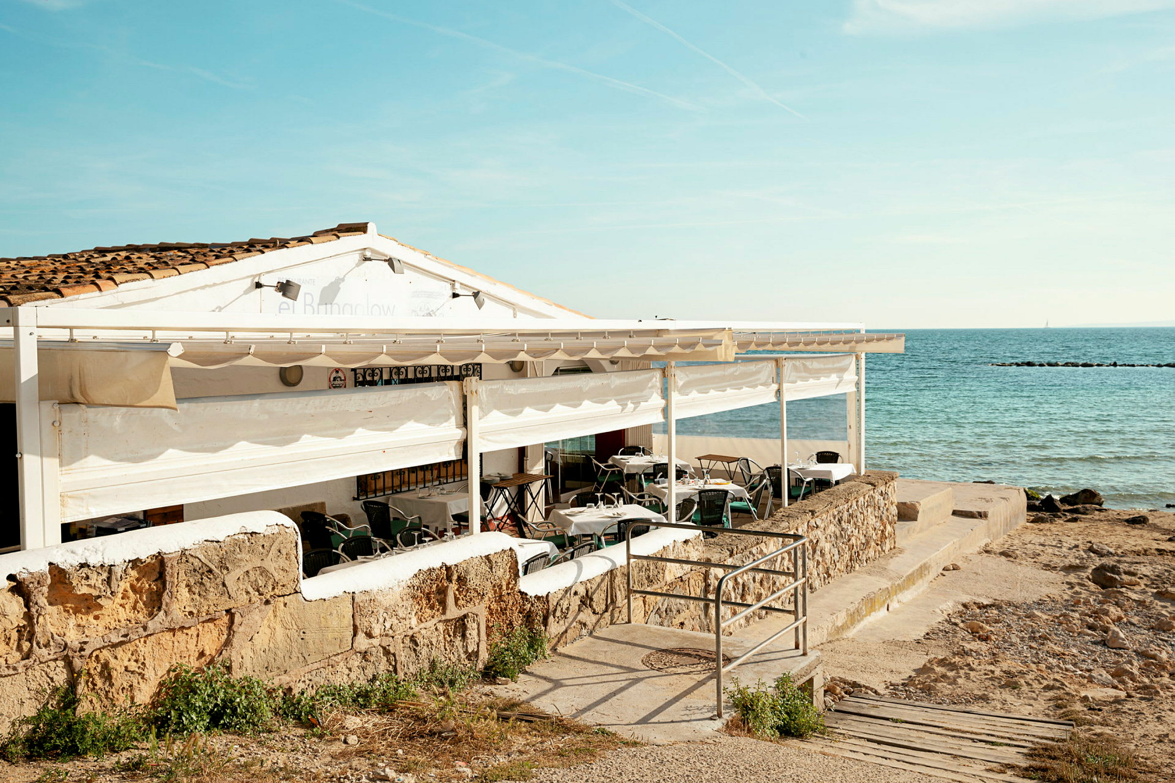 En restaurang med utomhusservering vid havet. (AI-genererad text)
