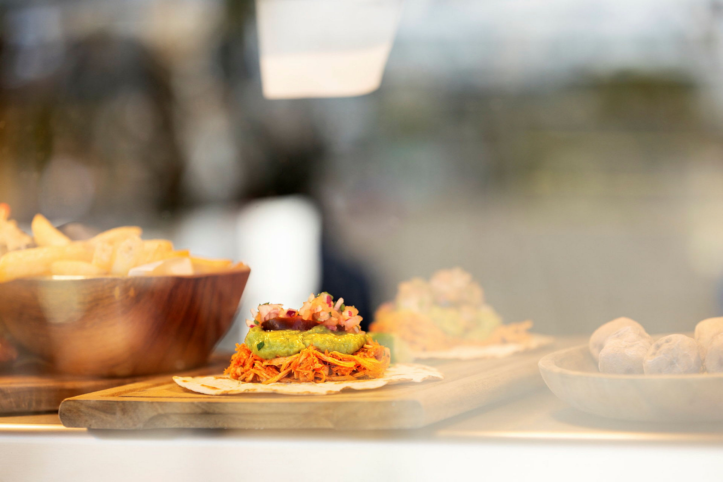 Mat som består av tortilla med pålägg, pommes frites i en skål och andra tillbehör. (AI-genererad text)