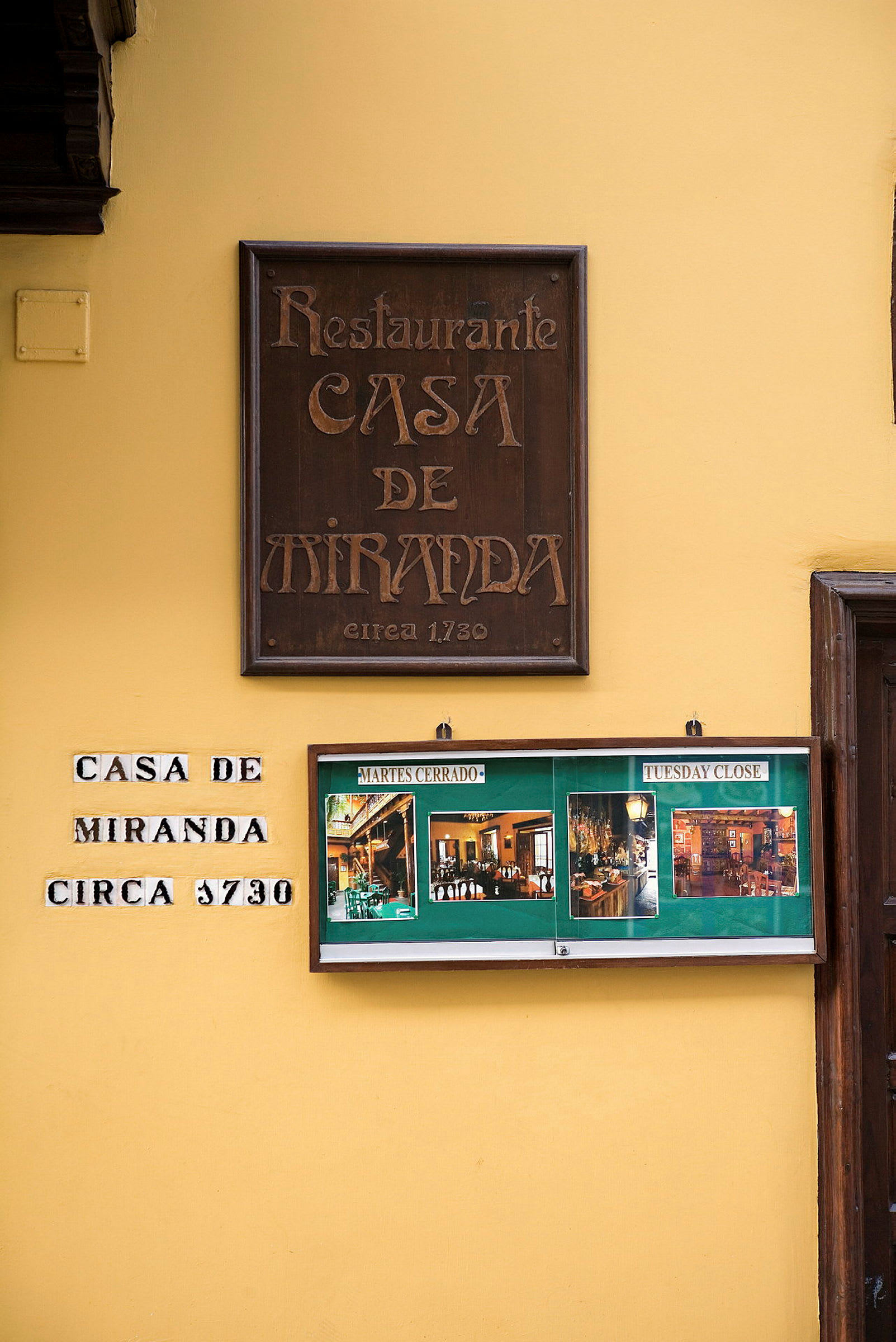 Gul vägg med restaurangskylten "Casa de Miranda" samt bilder av interiören. (AI-genererad text)