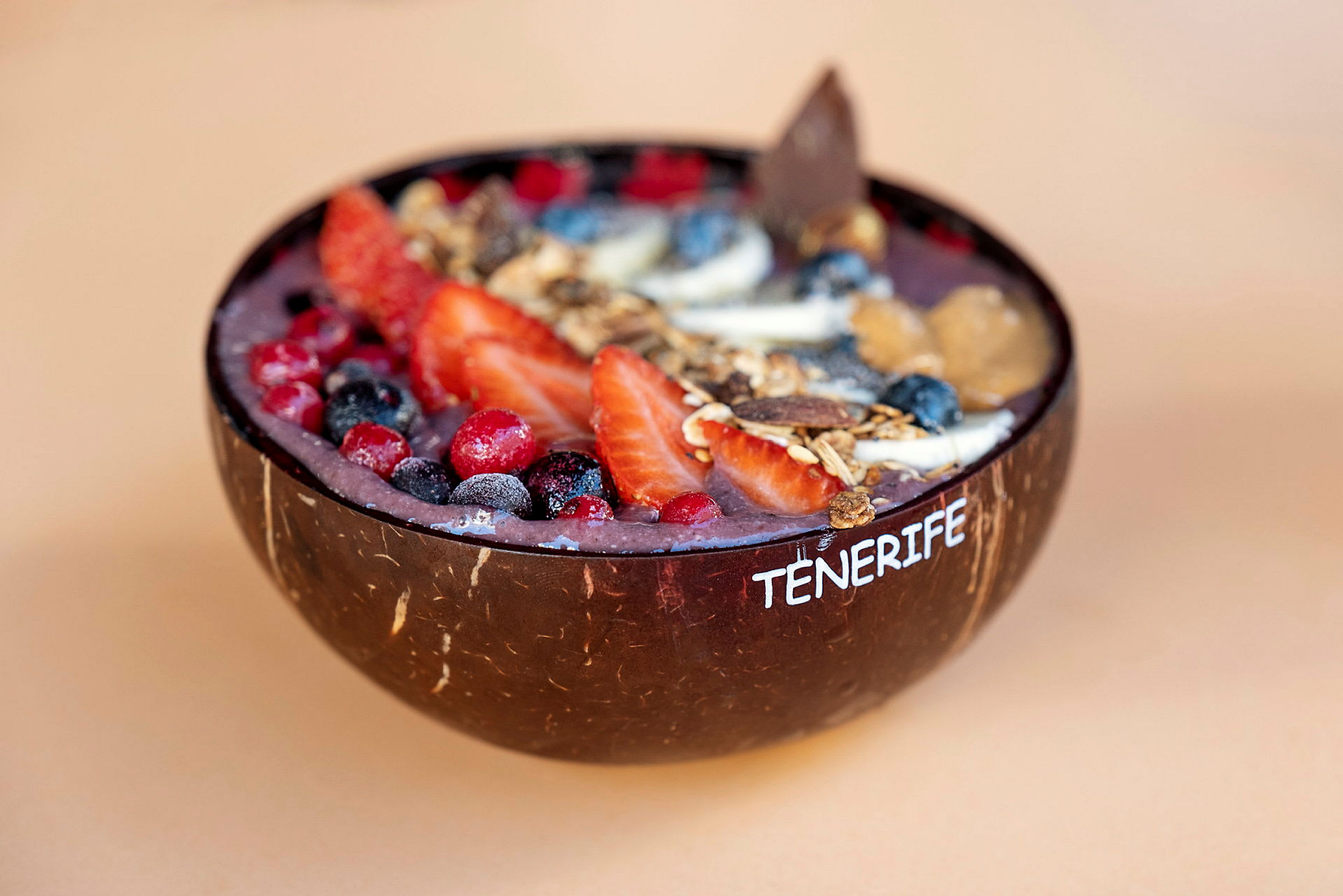 En acai-skål med bär och granola serverad i en kokosnötsskål. (AI-genererad text)