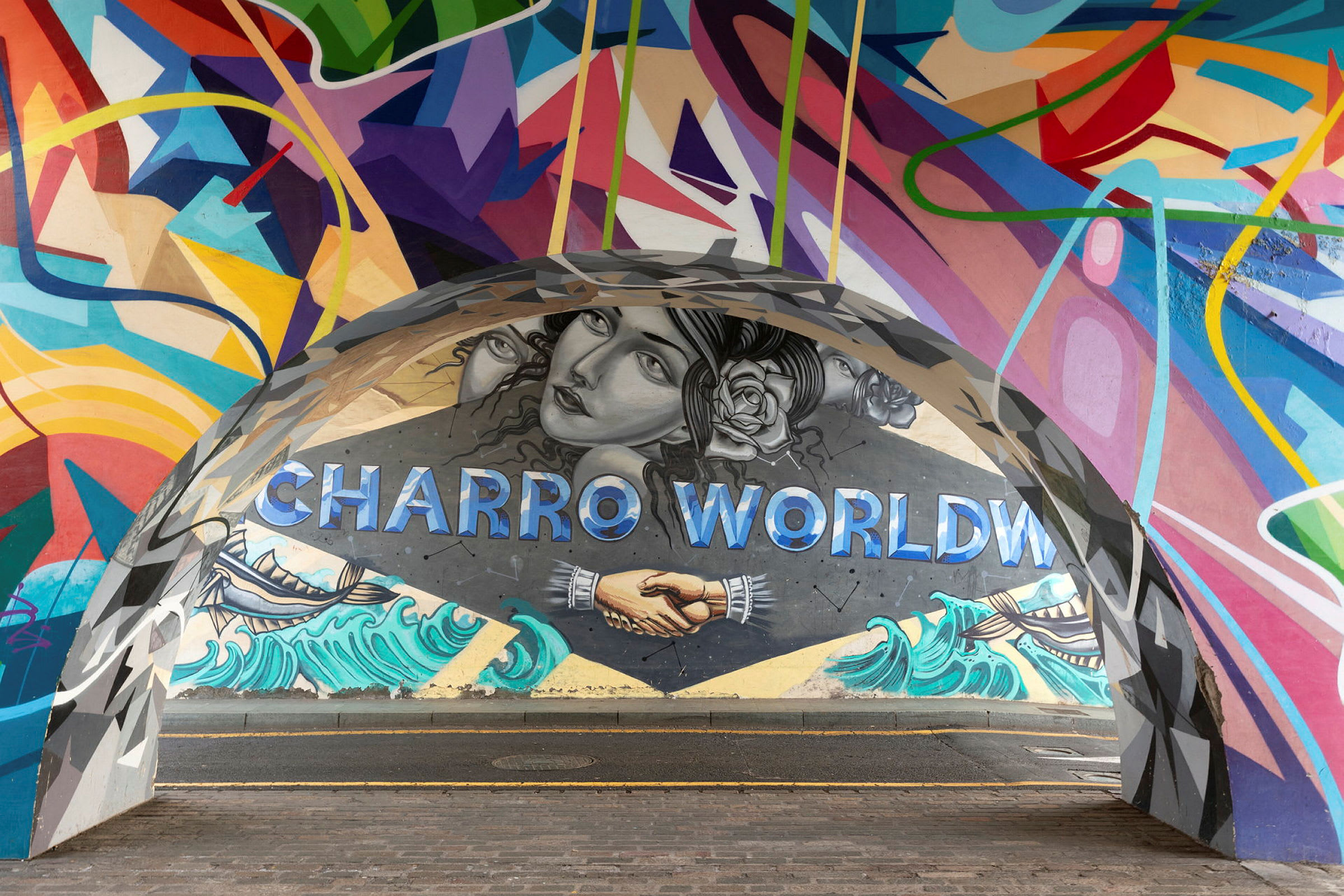 En färgglad muralmålning med texten 'Charro World', skakande händer och strandmotiv. (AI-genererad text)