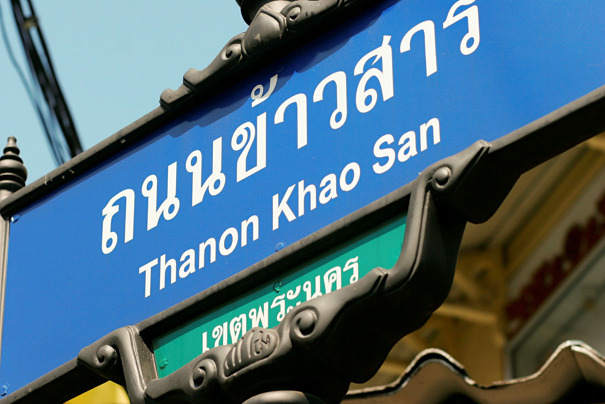 Gatuskylt med texten "Thanon Khao San". (AI-genererad text)