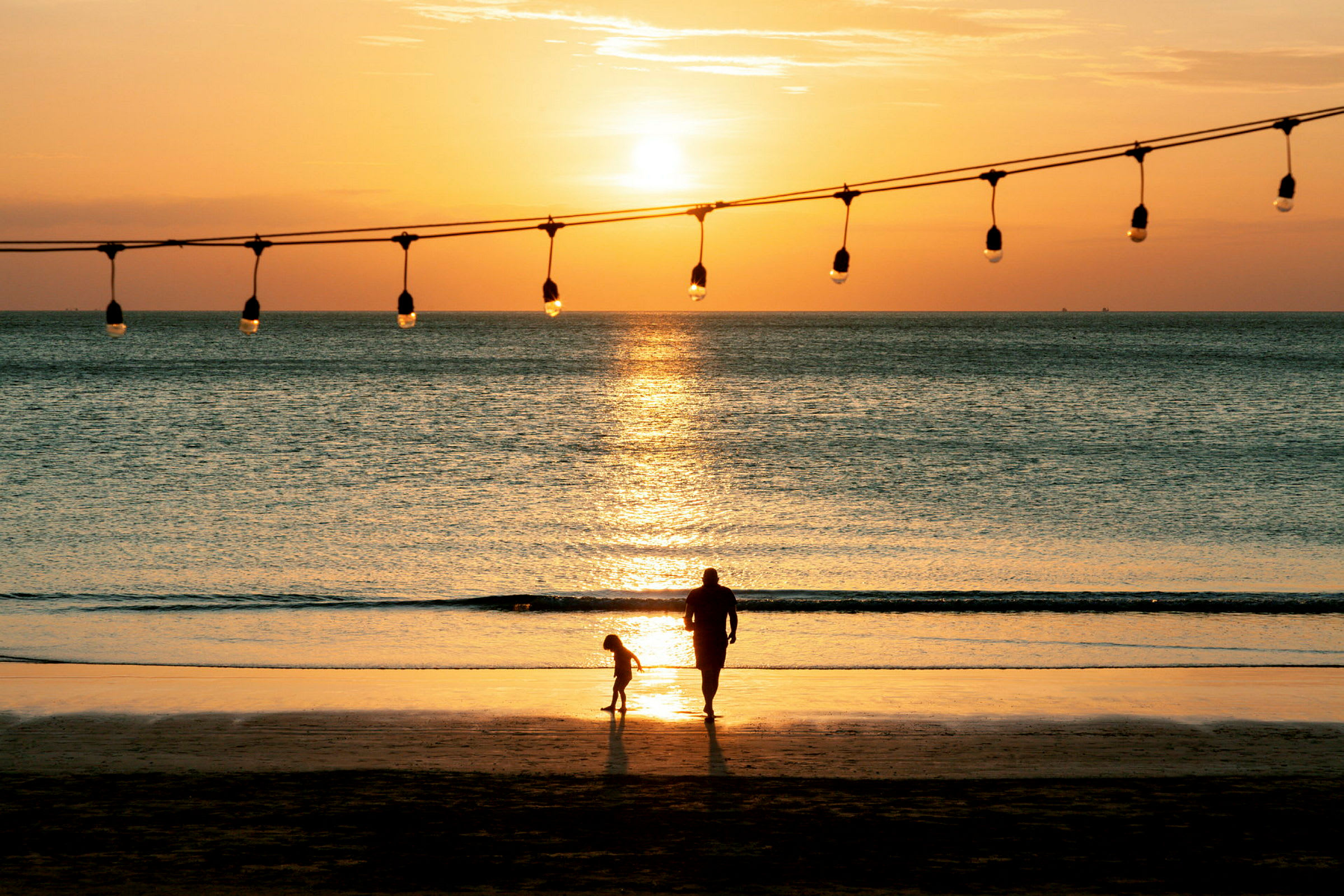 Två personer på en strand vid solnedgång. (AI-genererad text)