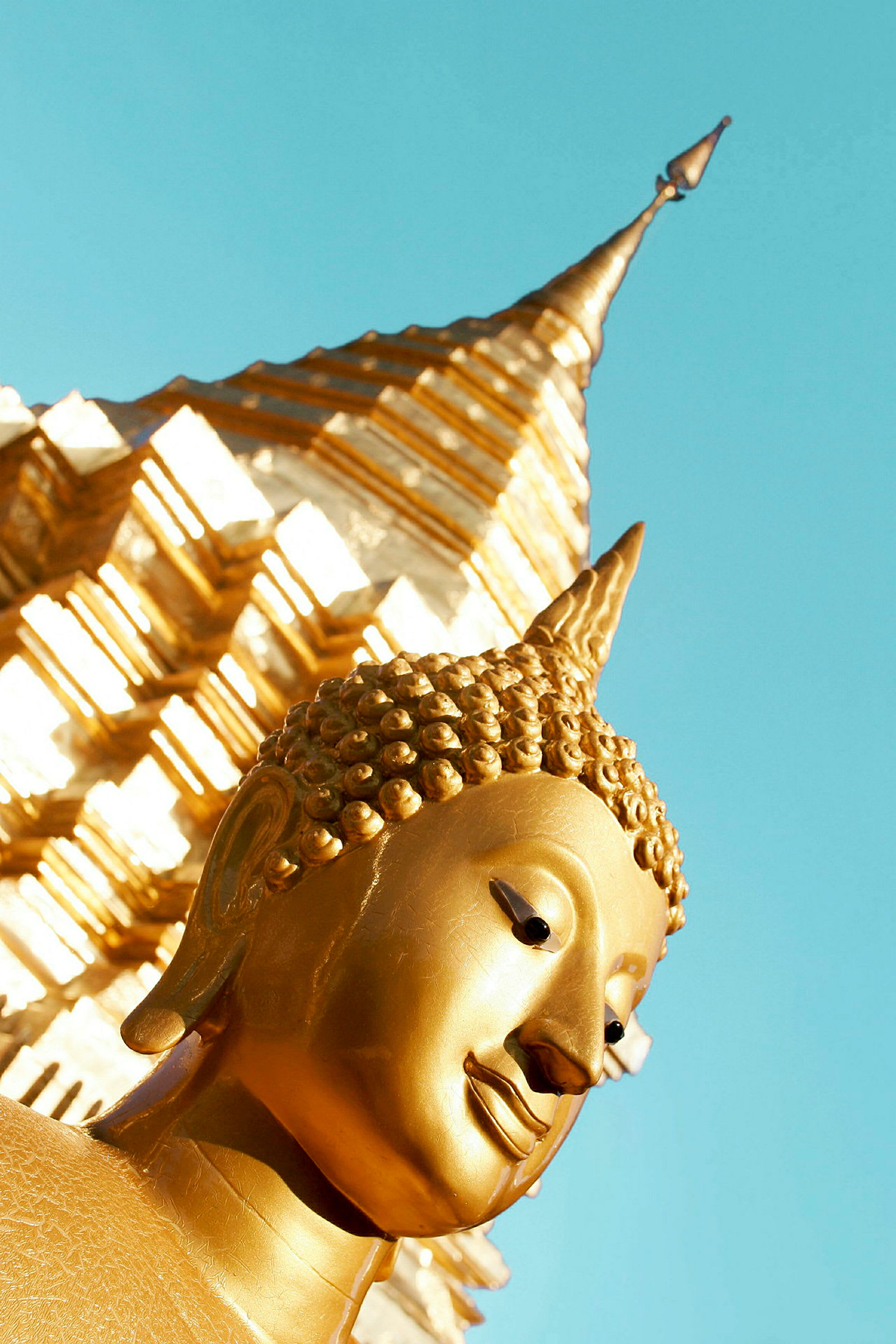 Gyllene detaljer av en buddhistisk staty med en stupa i bakgrunden. (AI-genererad text)