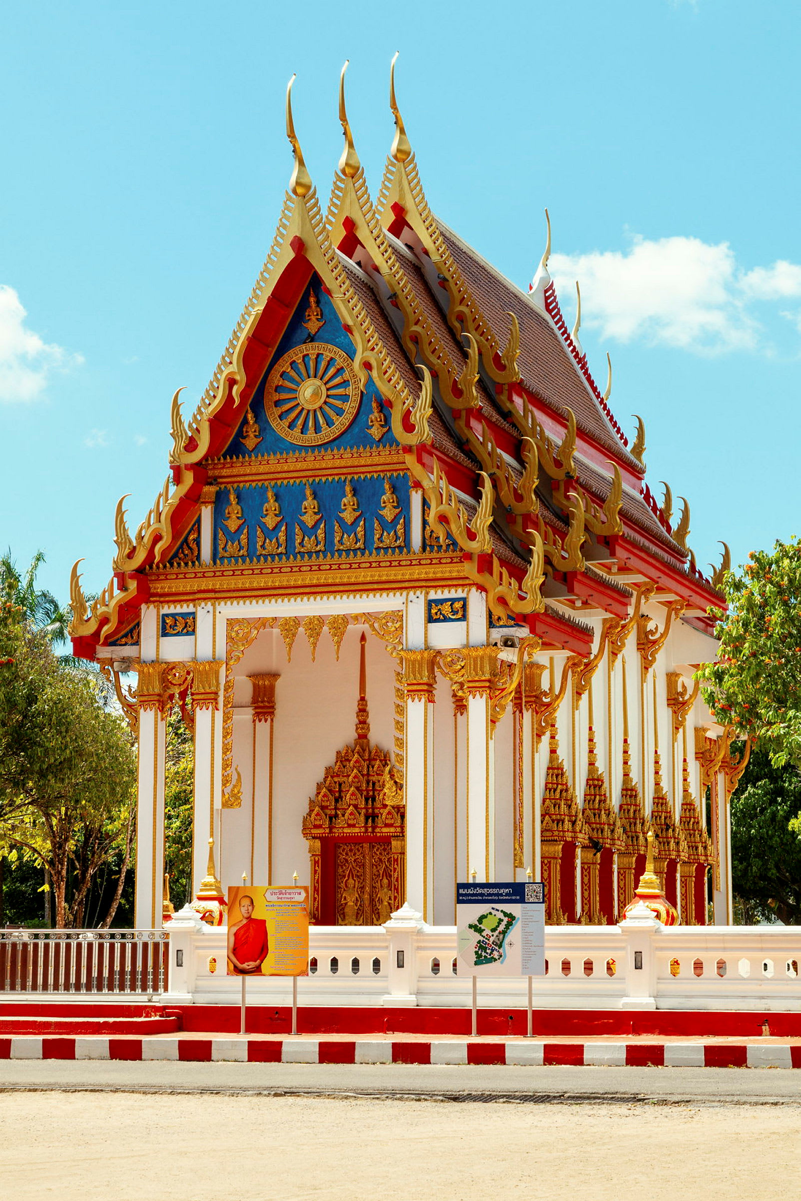 Rikligt dekorerad buddhistisk tempelbyggnad med ornamenterad fasad och spetsigt tak. Soligt väder. (AI-genererad text)