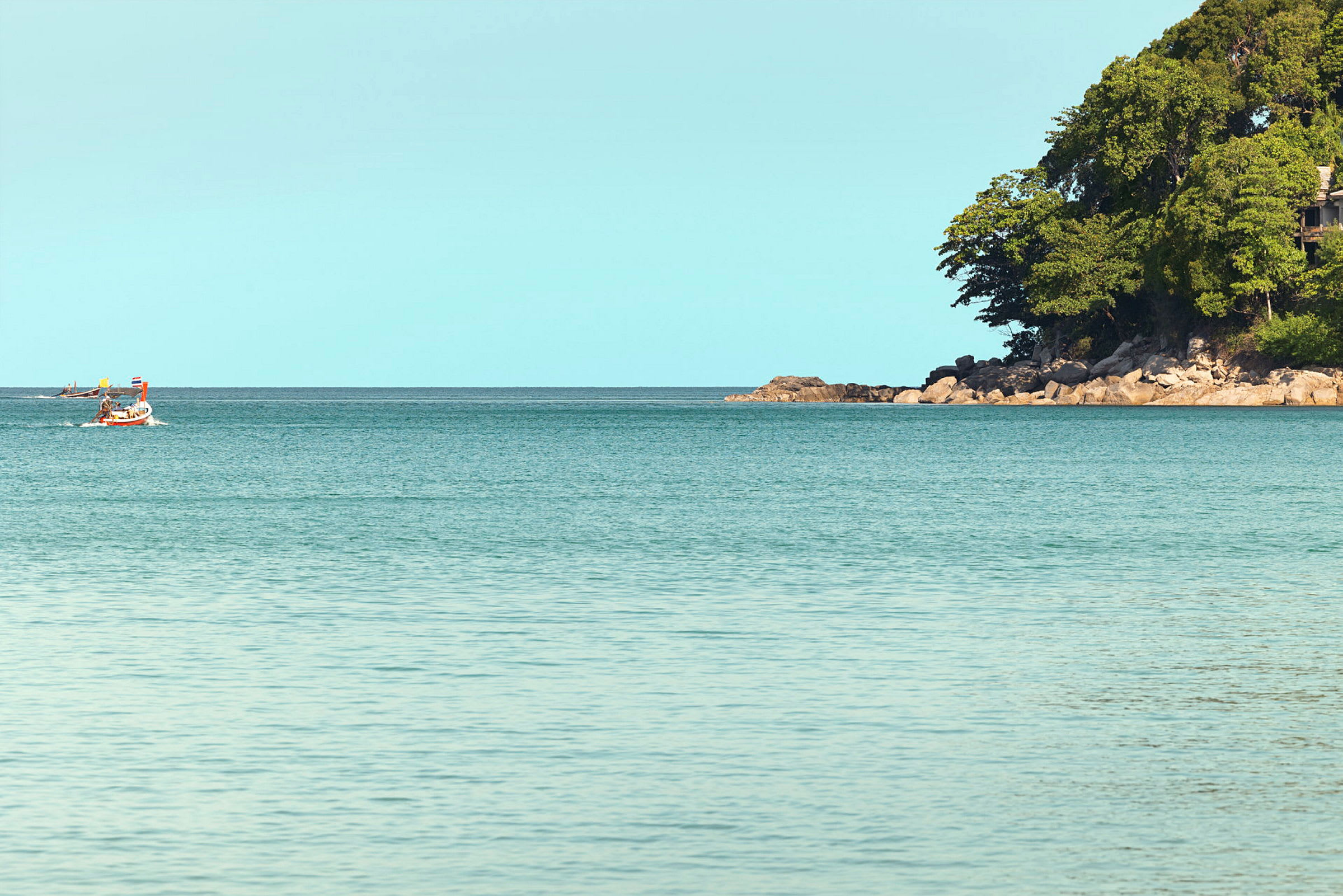En båt på havet med en skogstäckt udde i bakgrunden. (AI-genererad text)