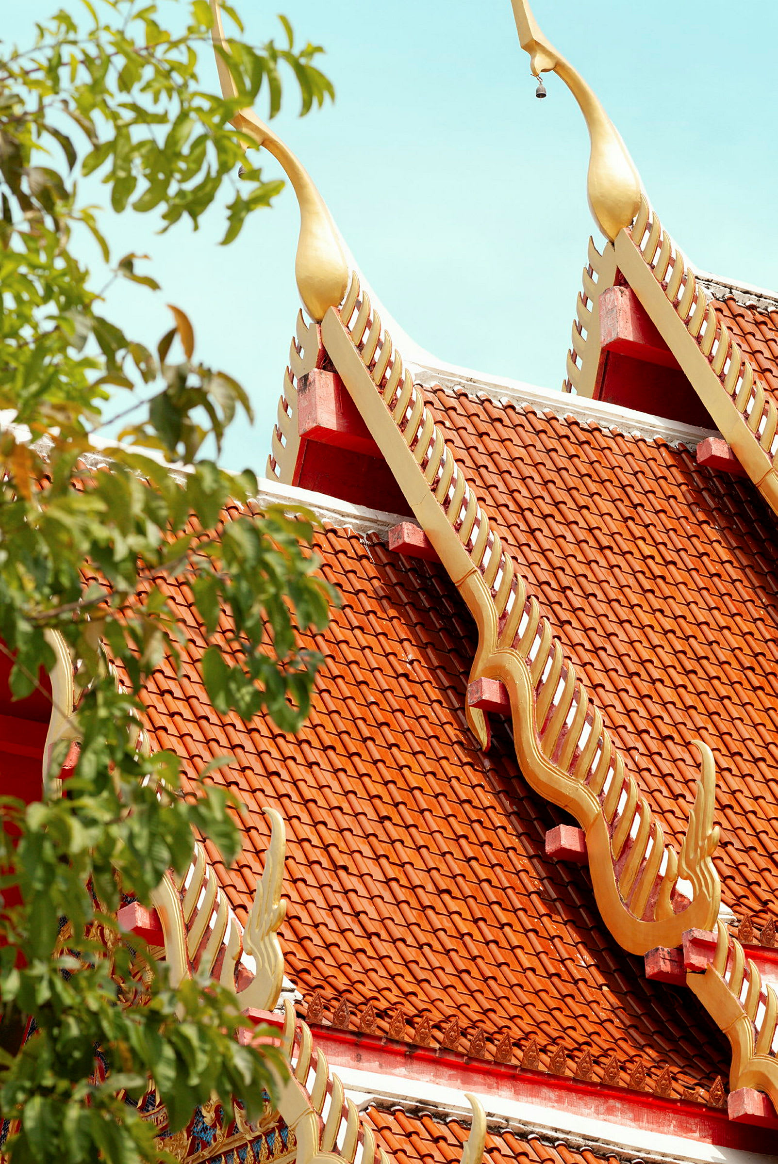 Detaljerad bild av ett tak på ett tempel med röda takpannor och dekorerade guldförsedda detaljer. (AI-genererad text)
