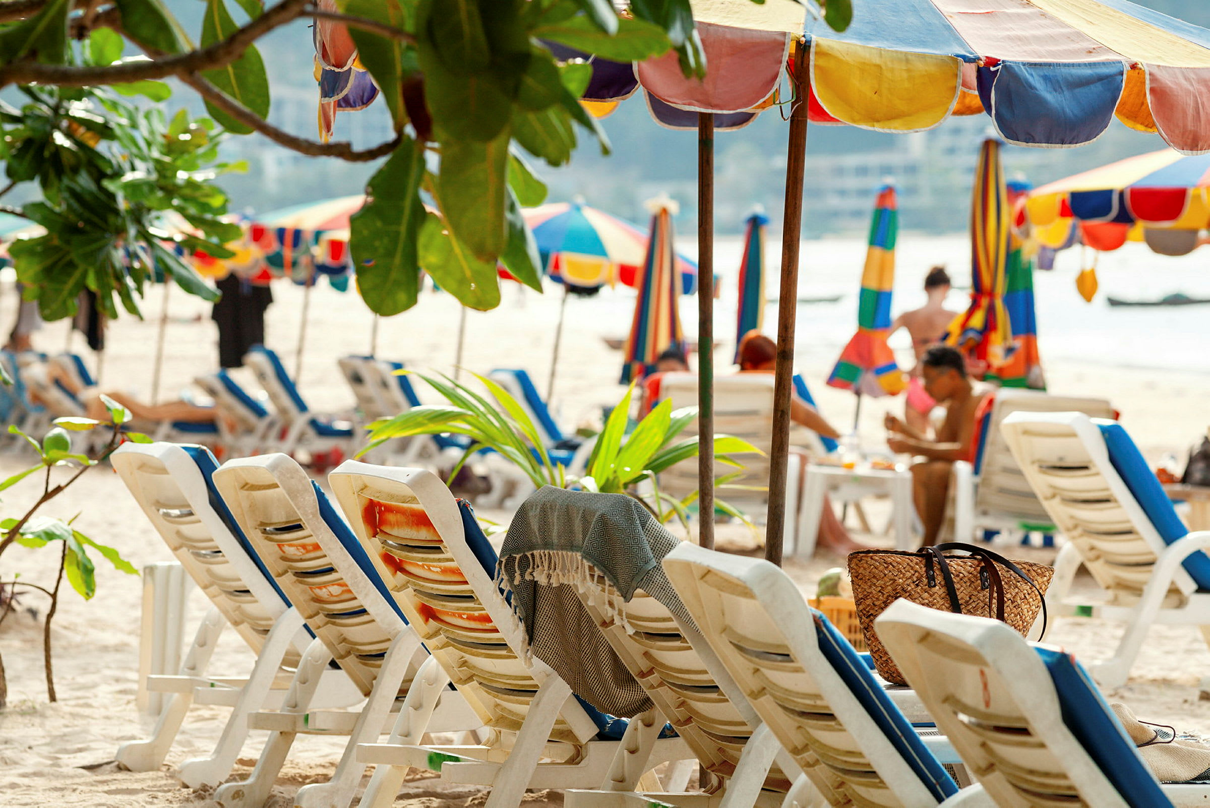 Strand med solstolar och färgglada parasoller. (AI-genererad text)