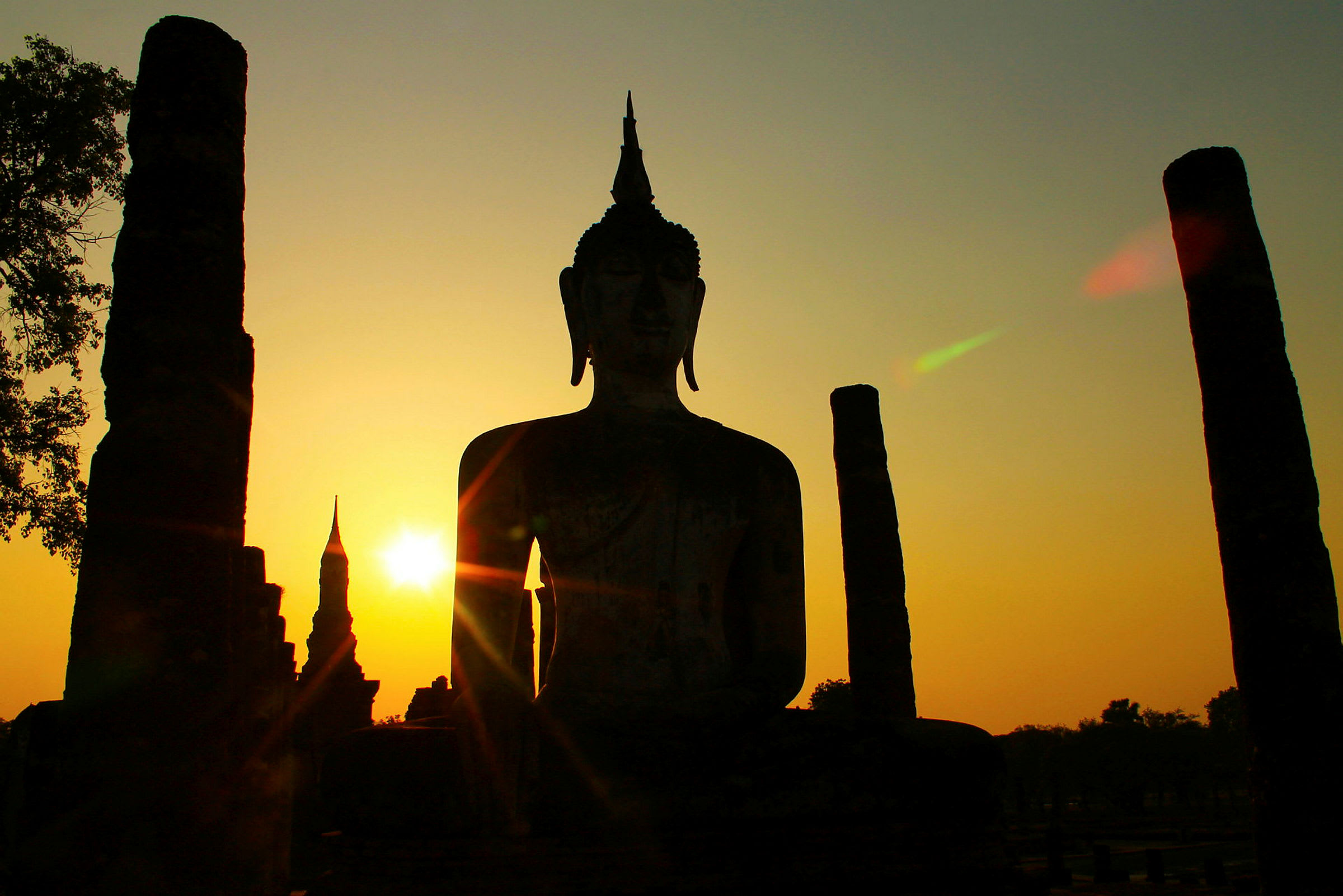 Buddhastaty i solnedgången i Sukhothai