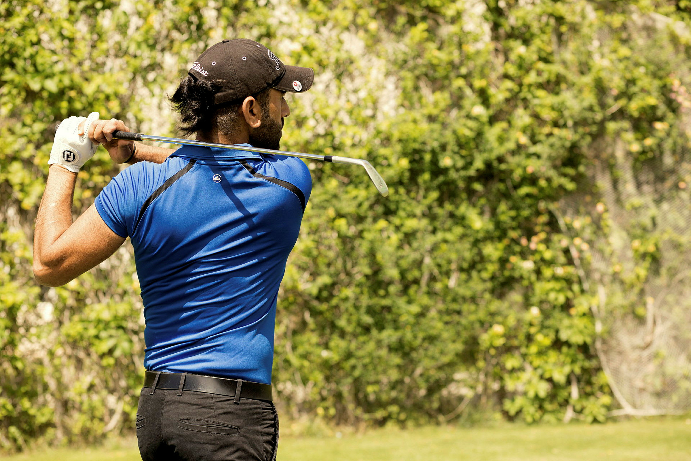 En person som spelar golf på en grön plats. (AI-genererad text)
