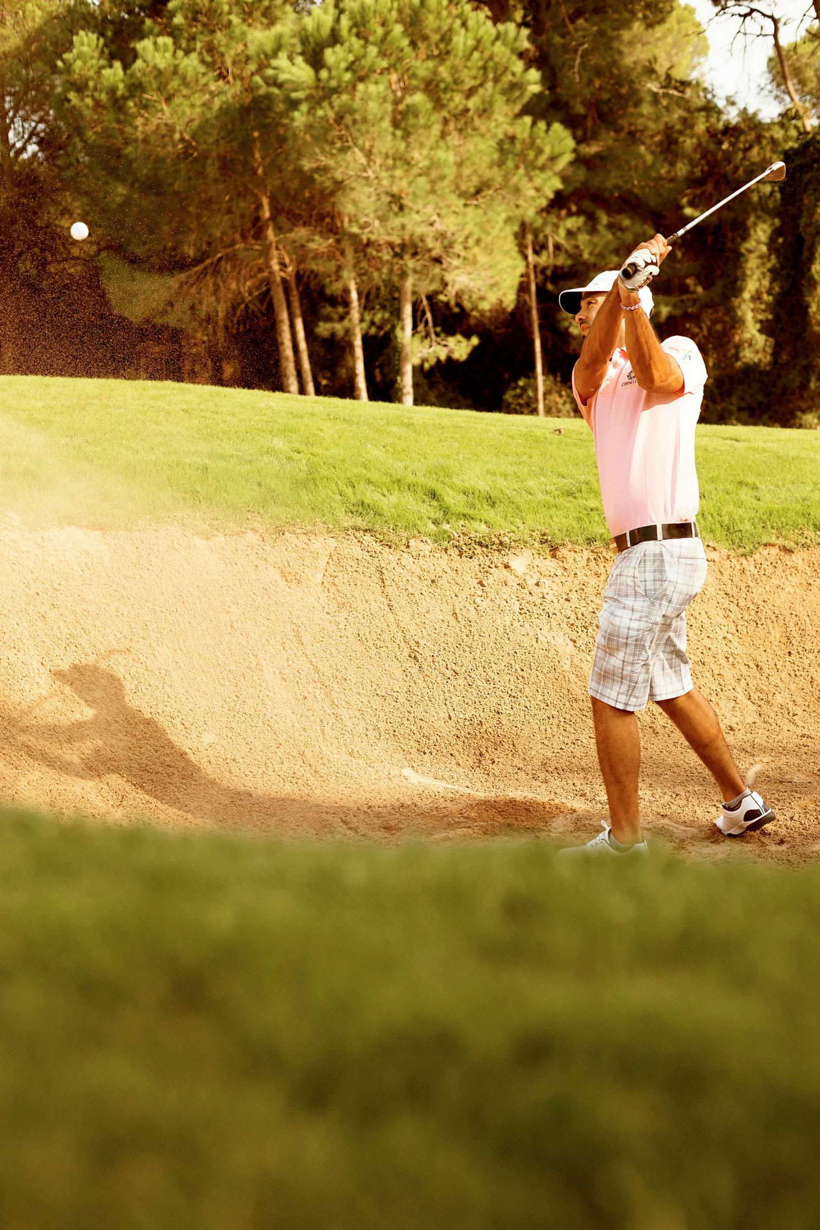 Person spelar golf från en sandbunker. (AI-genererad text)
