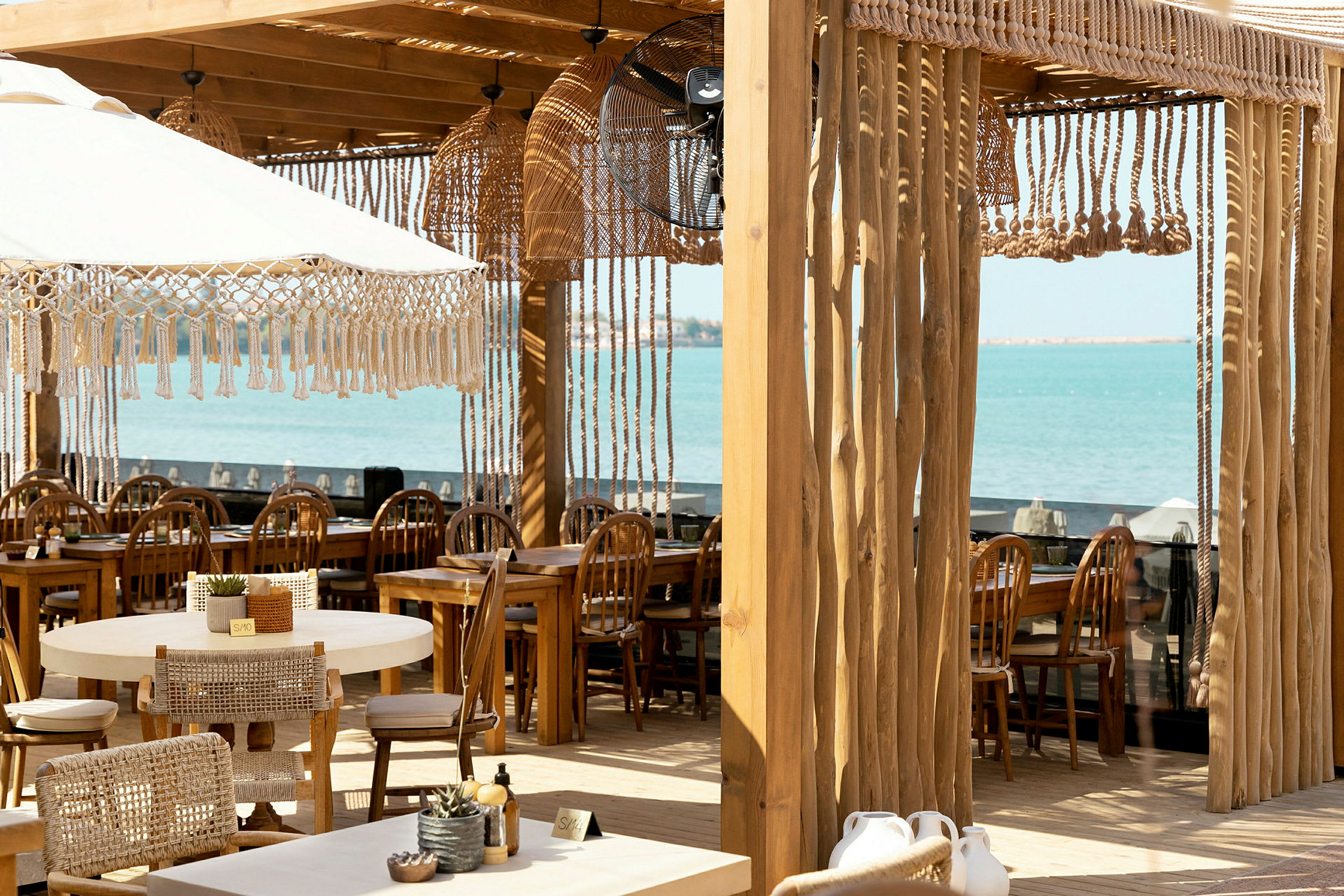 Restaurang med utsikt över havet, träinredning och stilfull dekor. (AI-genererad text)