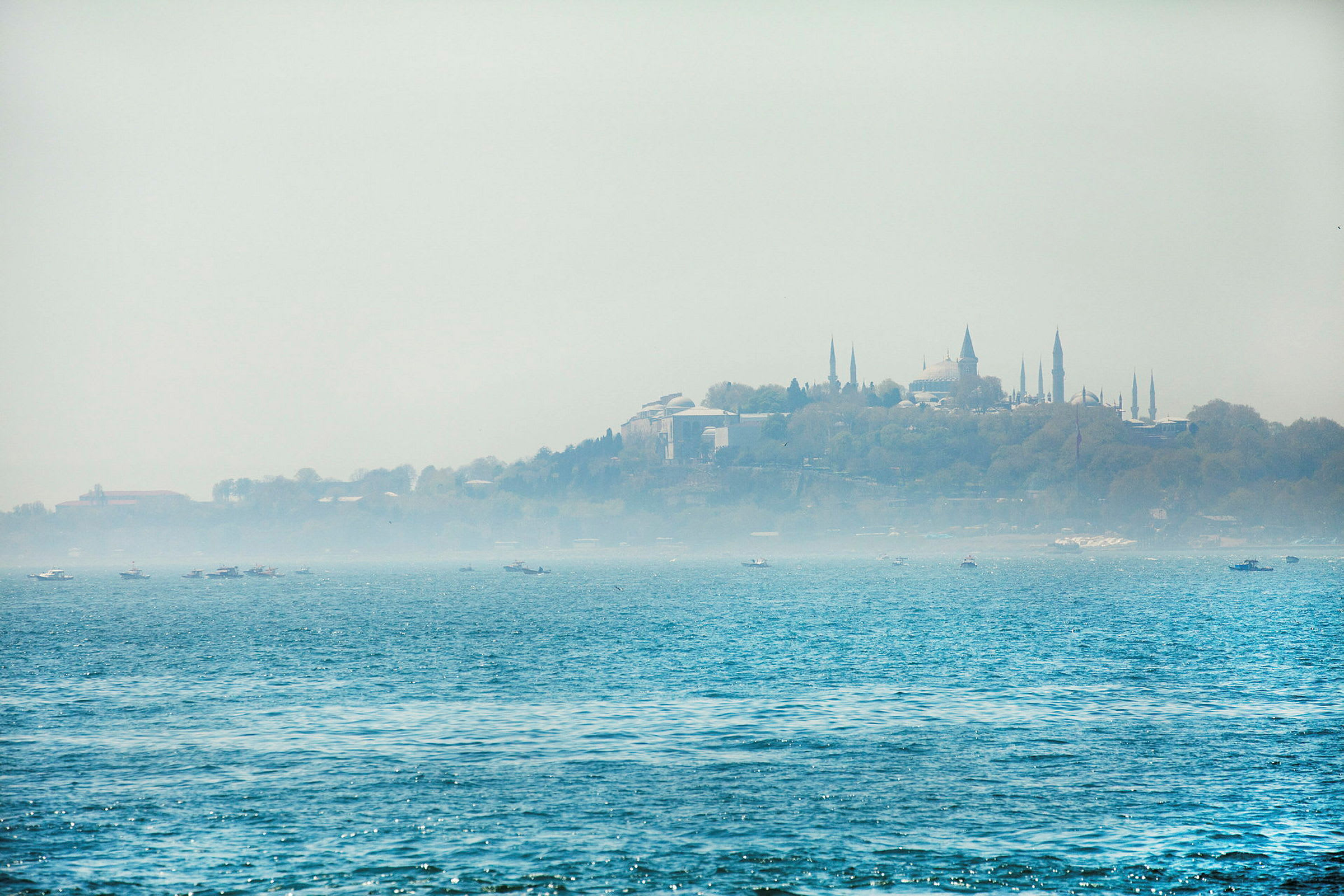 Vy över vatten med en stad i bakgrunden, inklusive byggnader och minareter. (AI-genererad text)