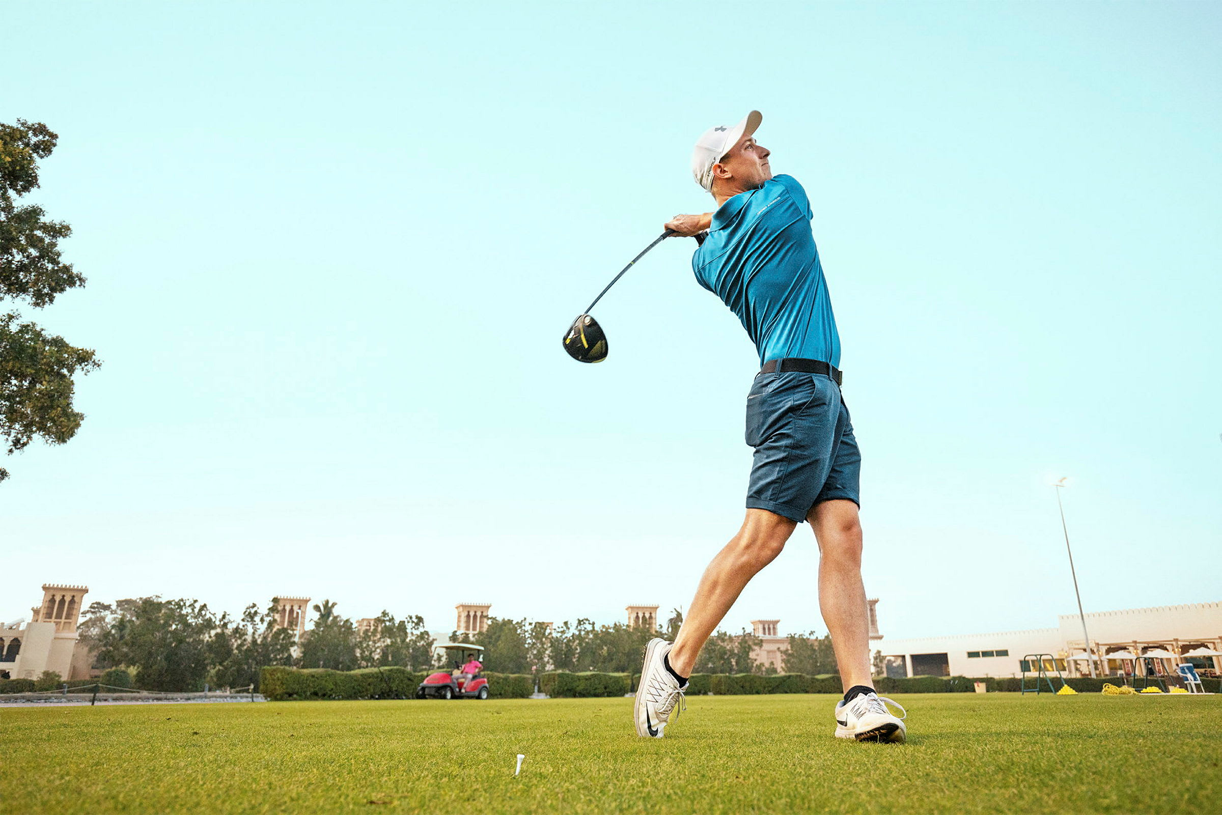 Person spelar golf och svingar en klubba på en grön golfbana. (AI-genererad text)